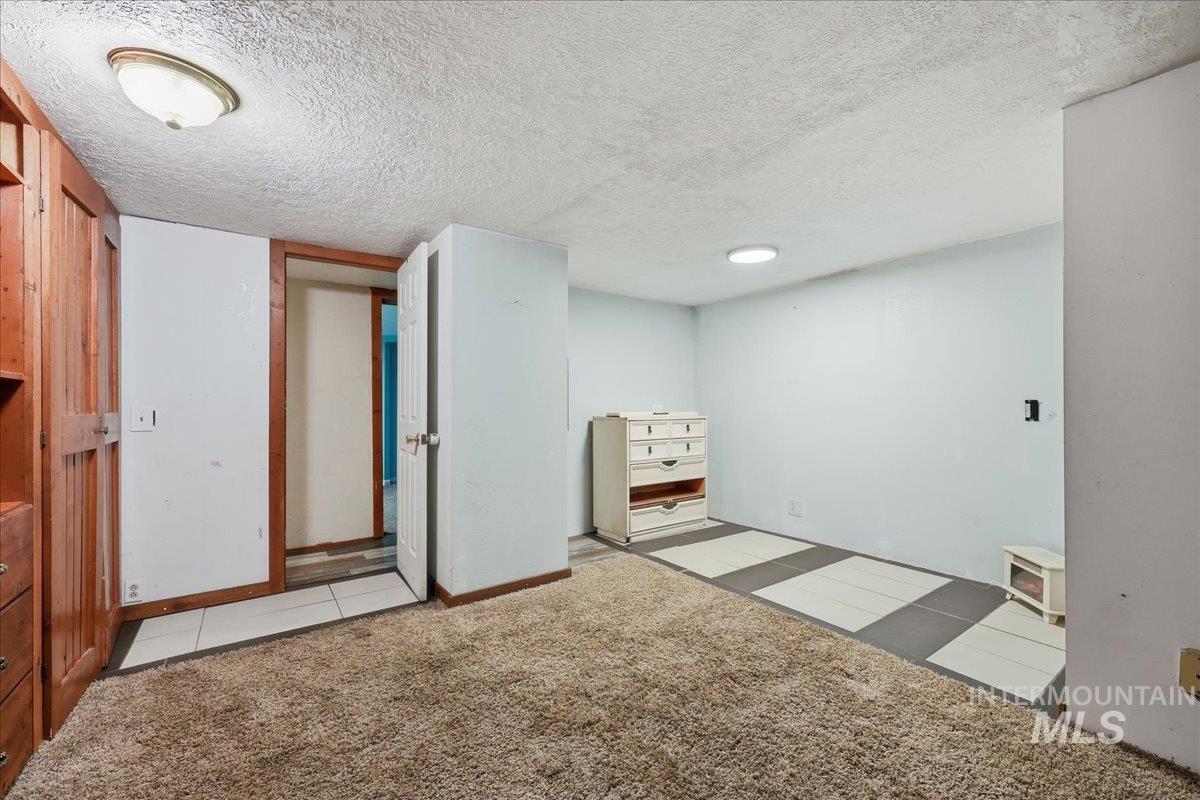 Finished below grade area with a textured ceiling and light colored carpet