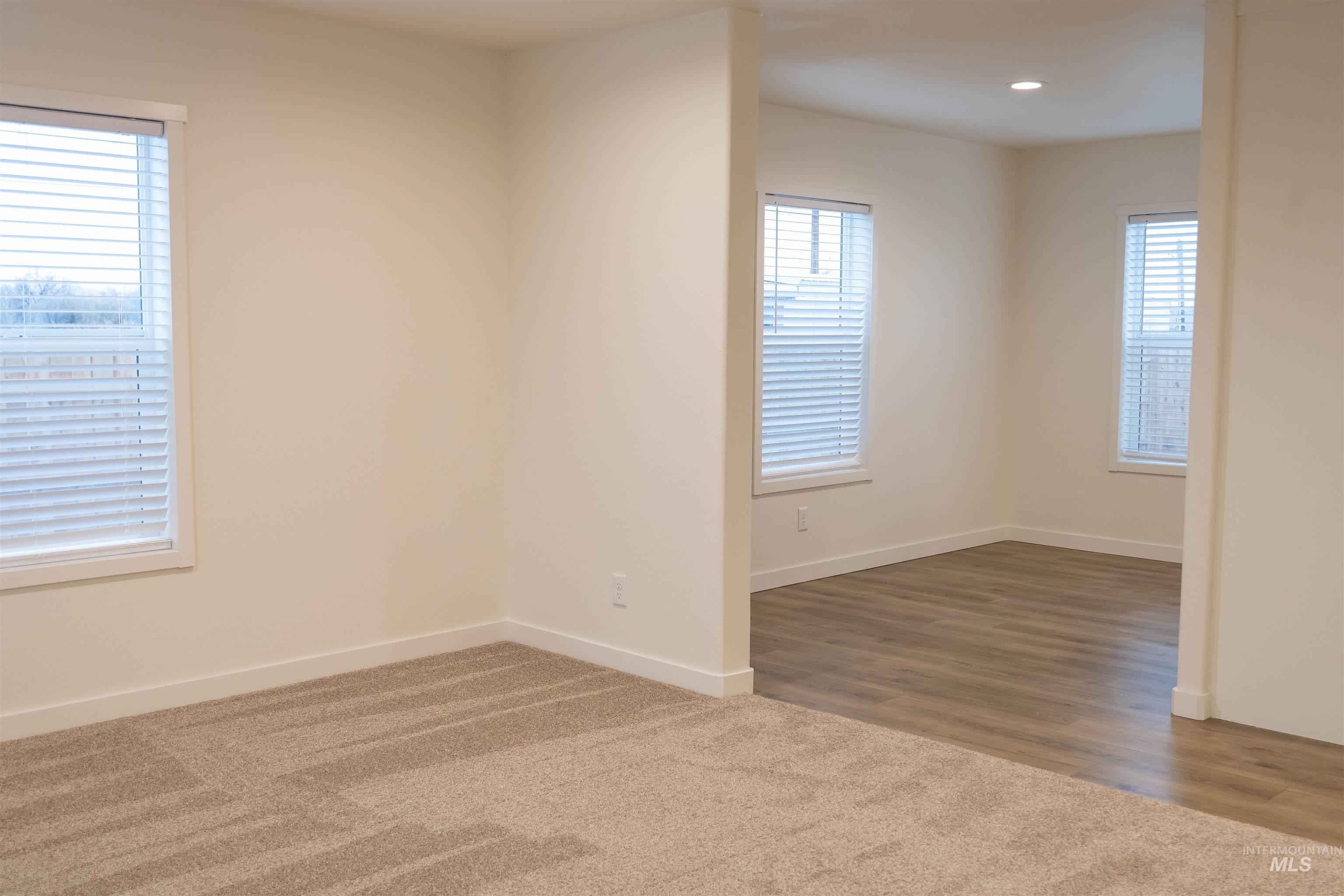 Carpeted spare room featuring baseboards and recessed lighting