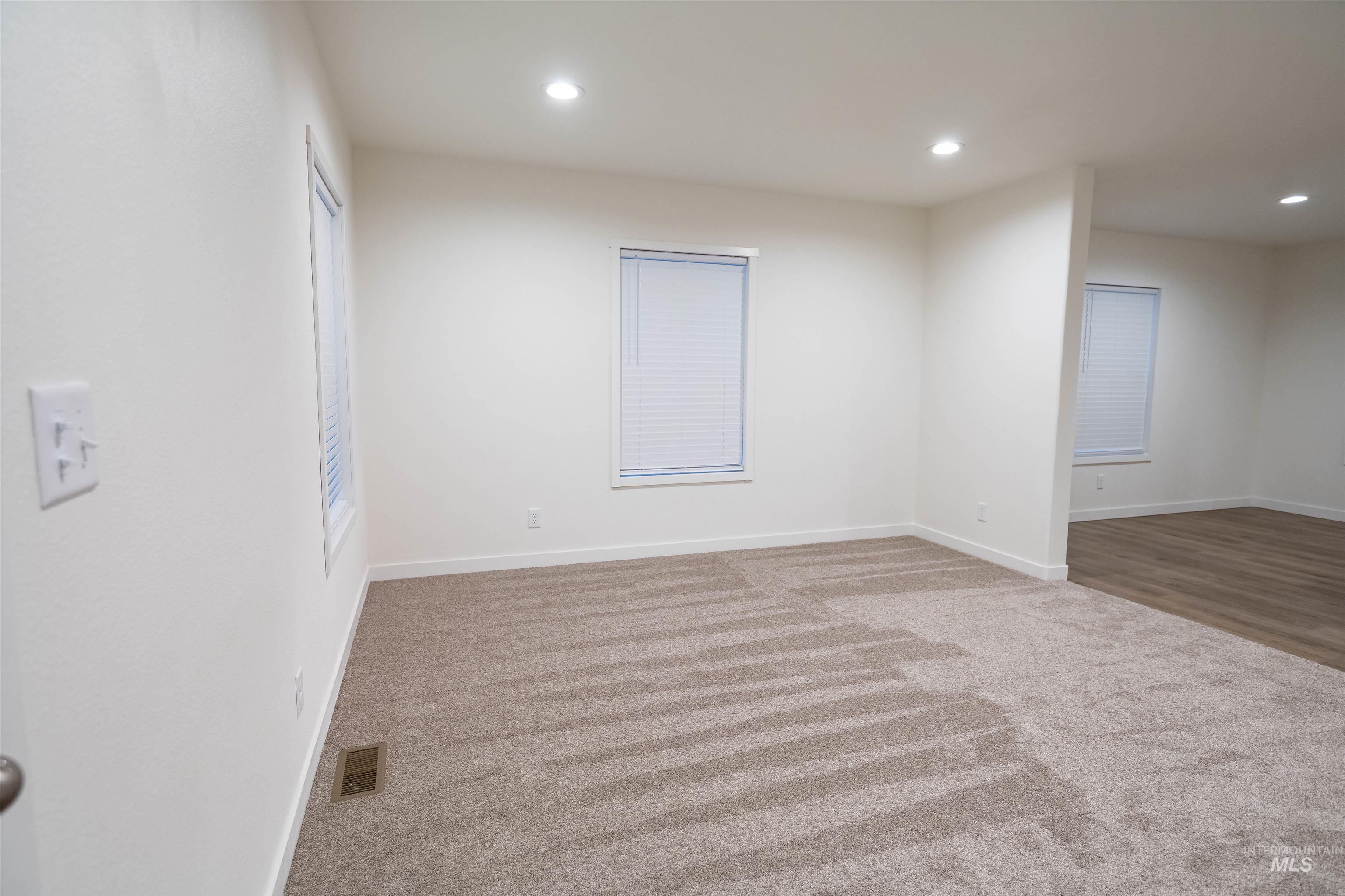 Carpeted empty room featuring recessed lighting
