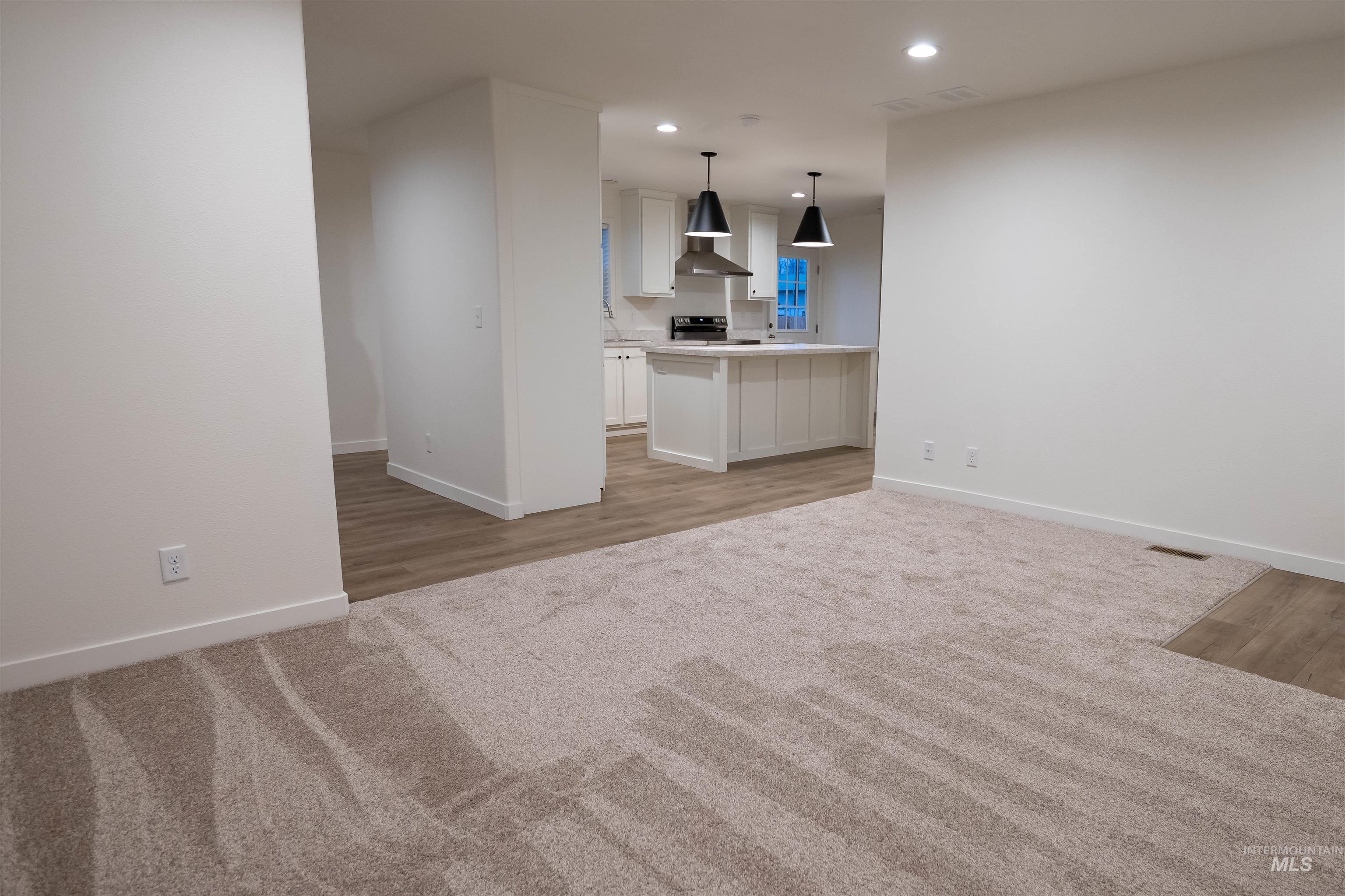 Unfurnished living room featuring recessed lighting and light colored carpet