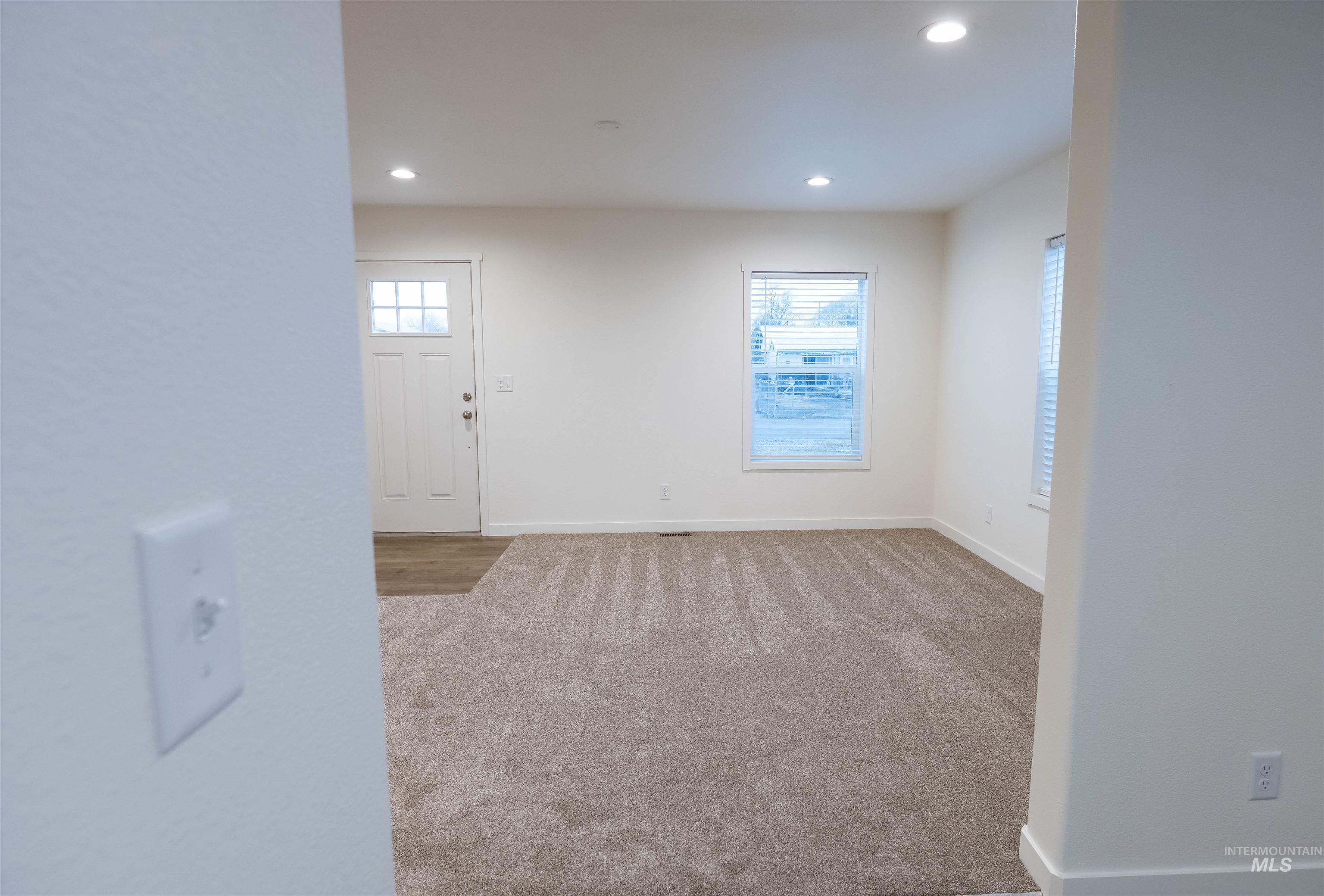 Carpeted foyer entrance with recessed lighting and baseboards