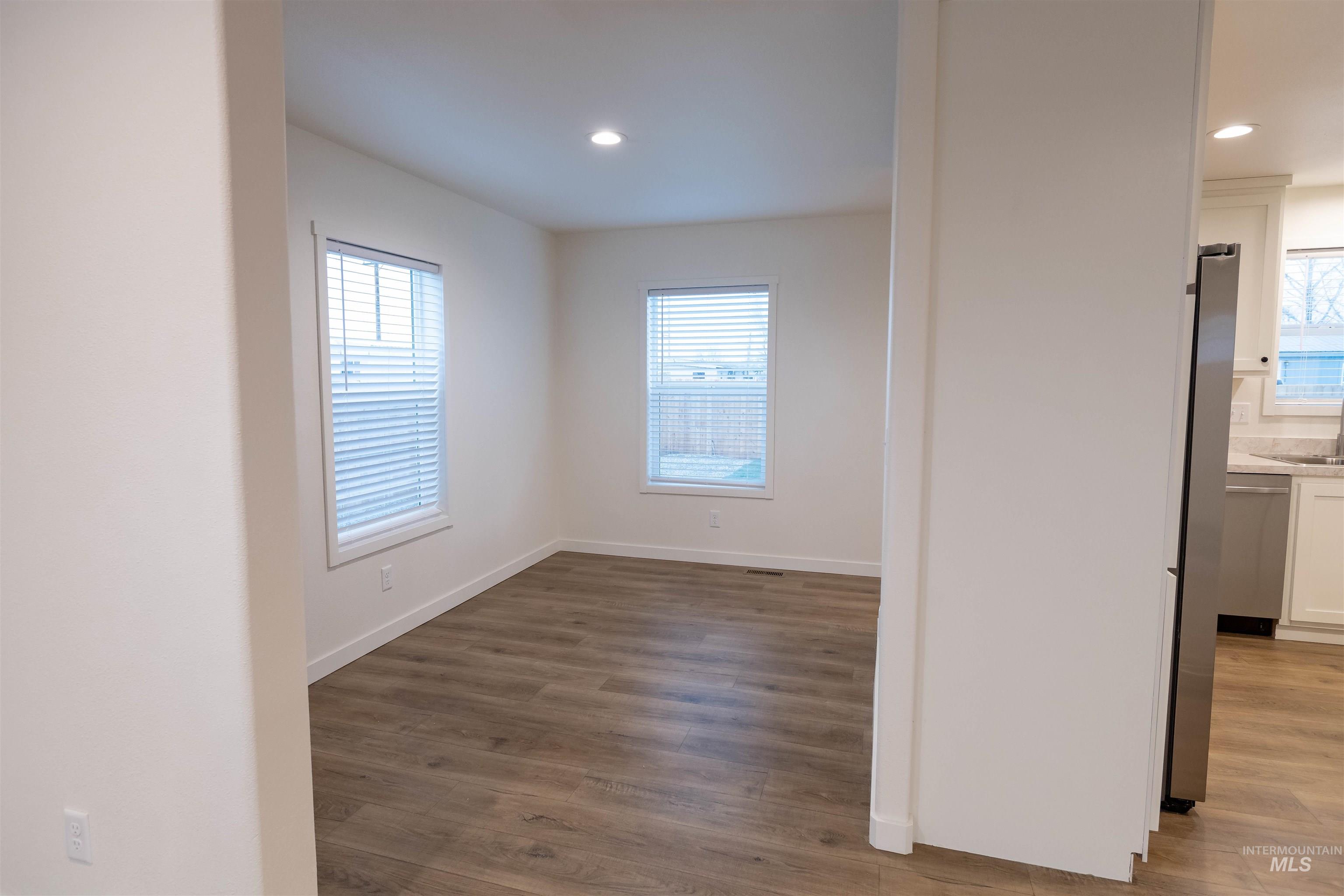 Spare room with dark wood-style floors and recessed lighting