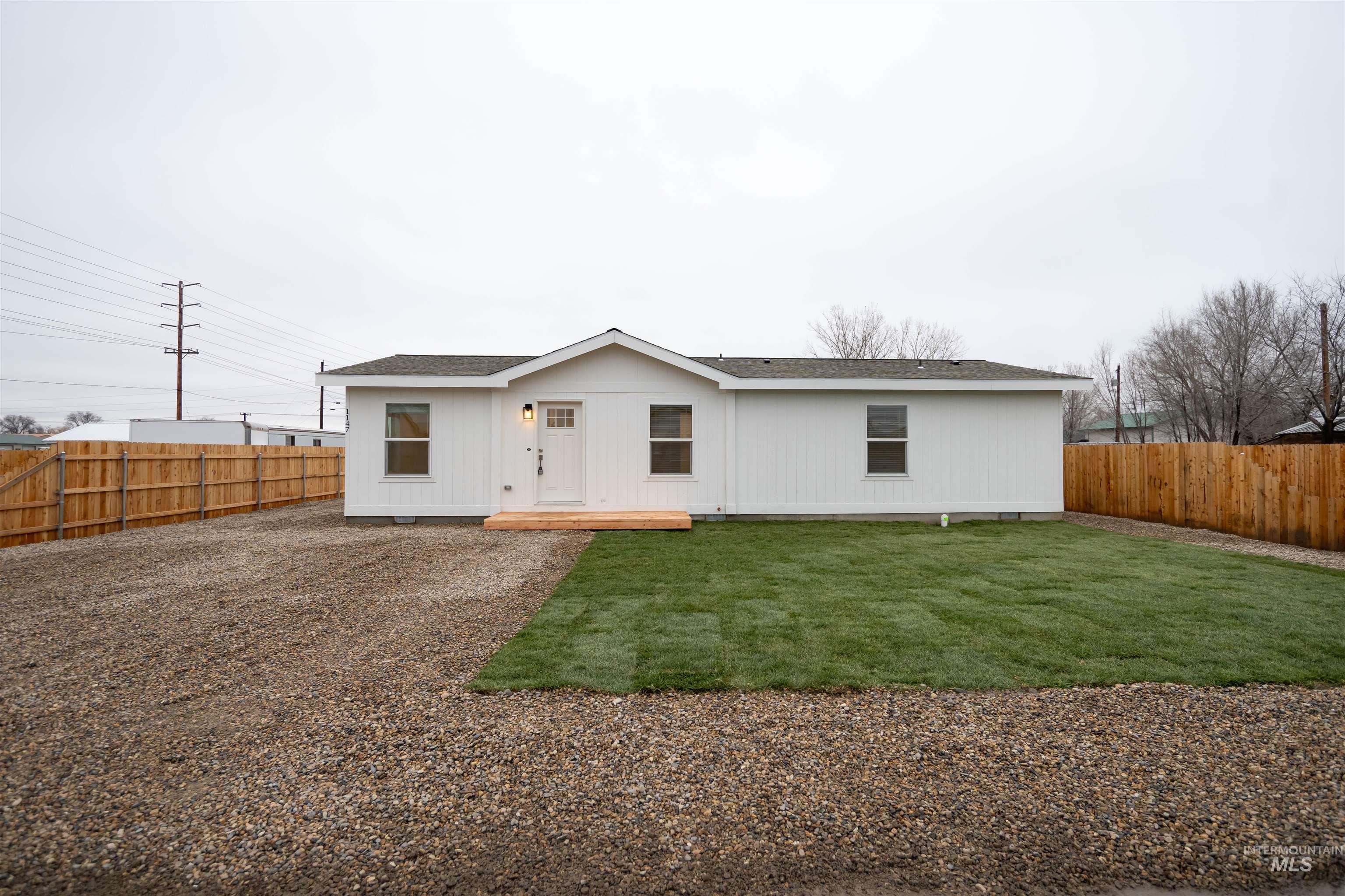 View of front facade featuring a fenced backyard and a shingled roof