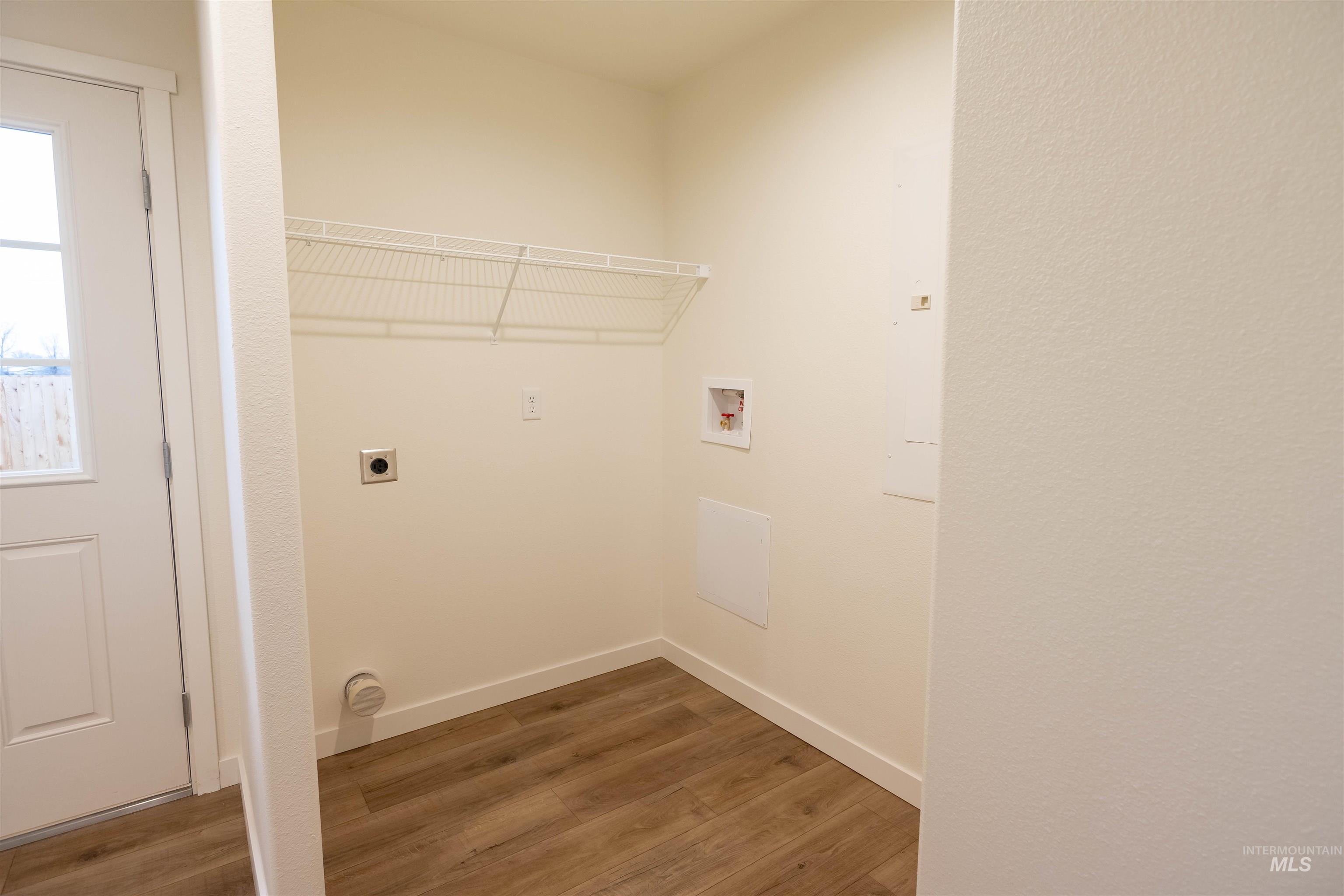 Laundry room featuring wood finished floors, hookup for a washing machine, and electric dryer hookup