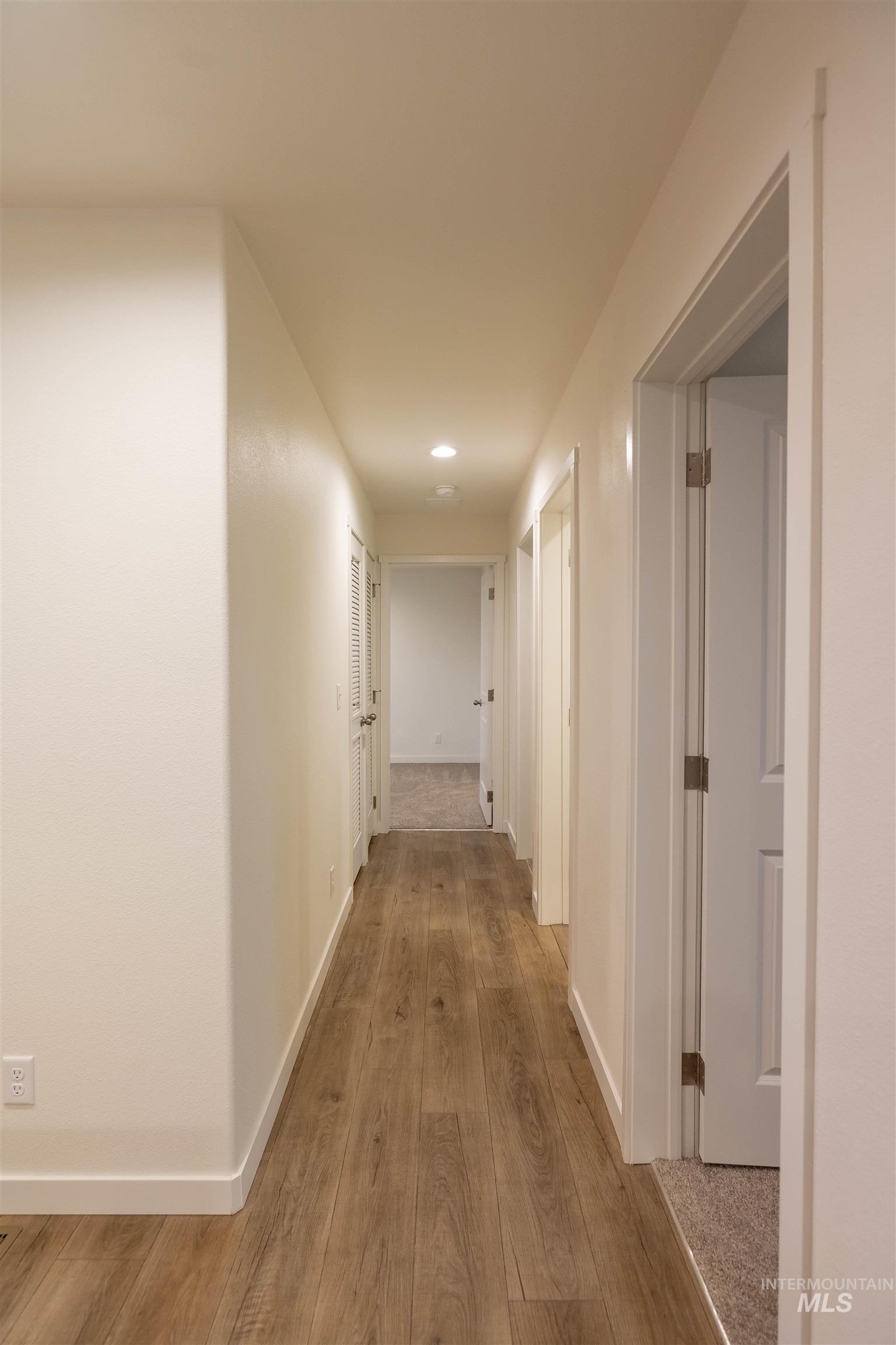 Hallway featuring wood finished floors and recessed lighting