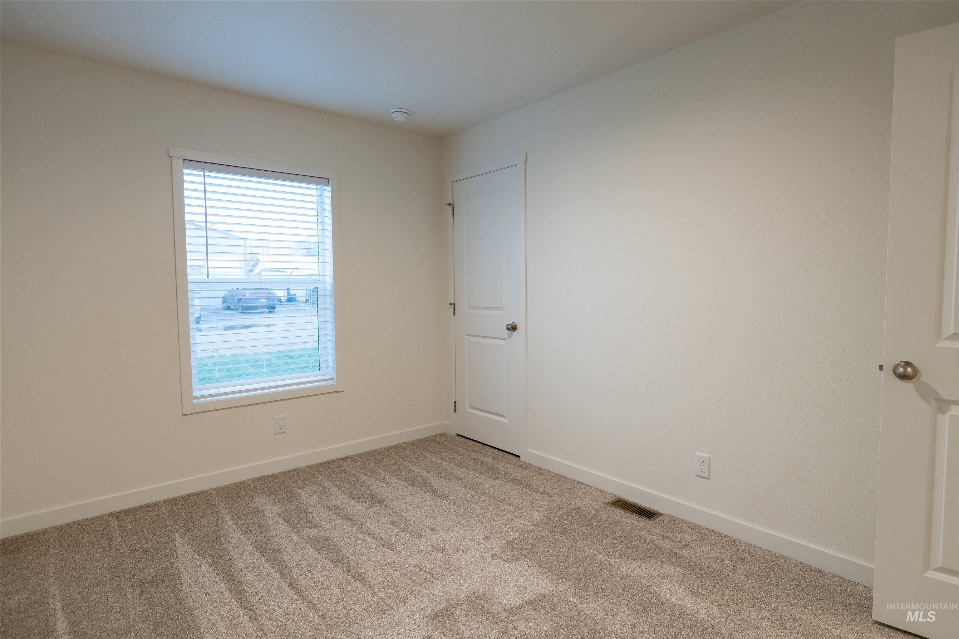 Empty room featuring light carpet and baseboards
