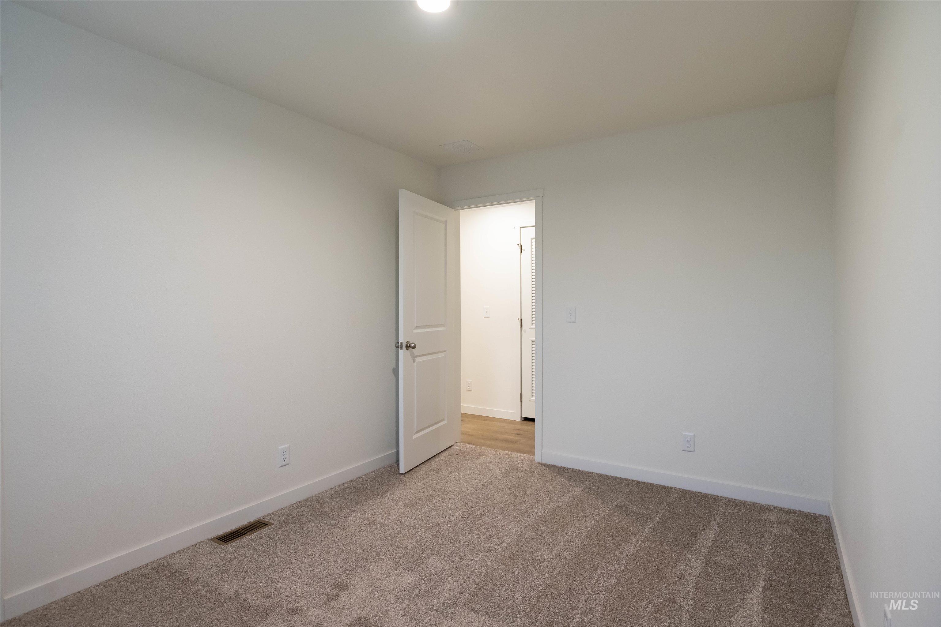 Carpeted empty room with baseboards