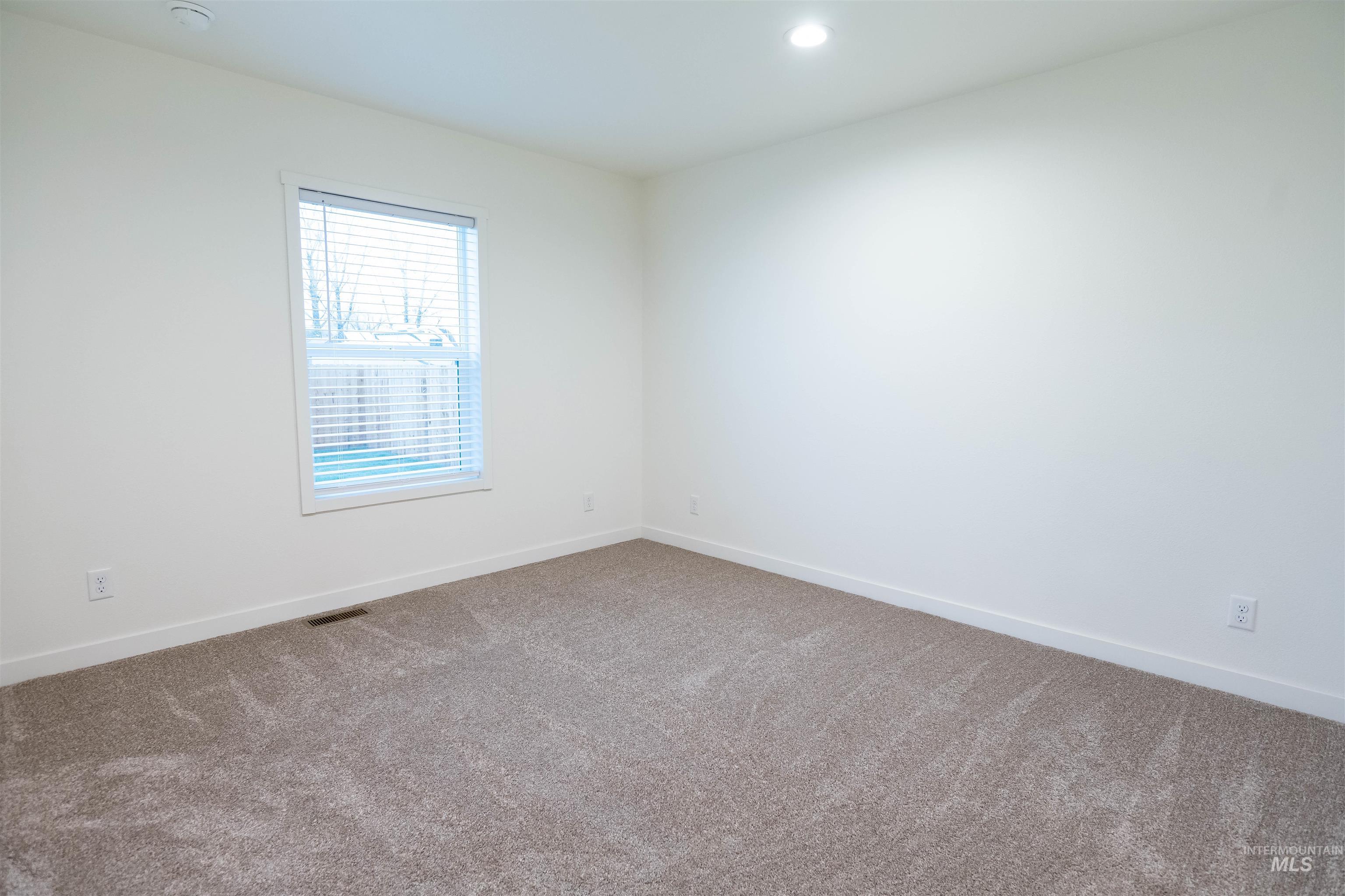 Empty room with carpet and recessed lighting