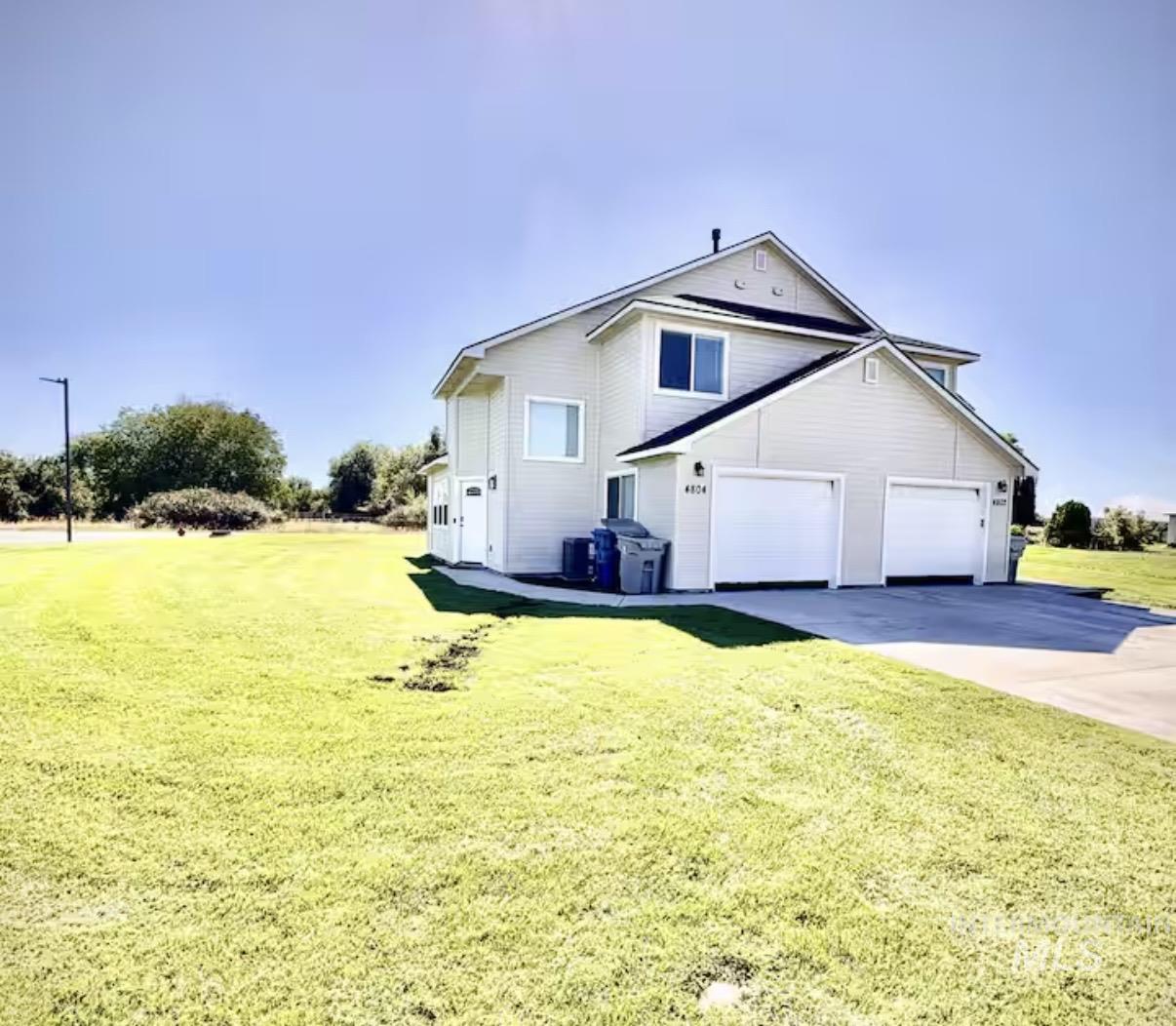 View of property exterior featuring a yard, driveway, and a garage