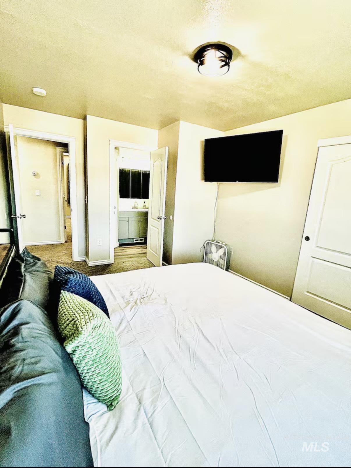 Bedroom featuring ensuite bathroom and baseboards
