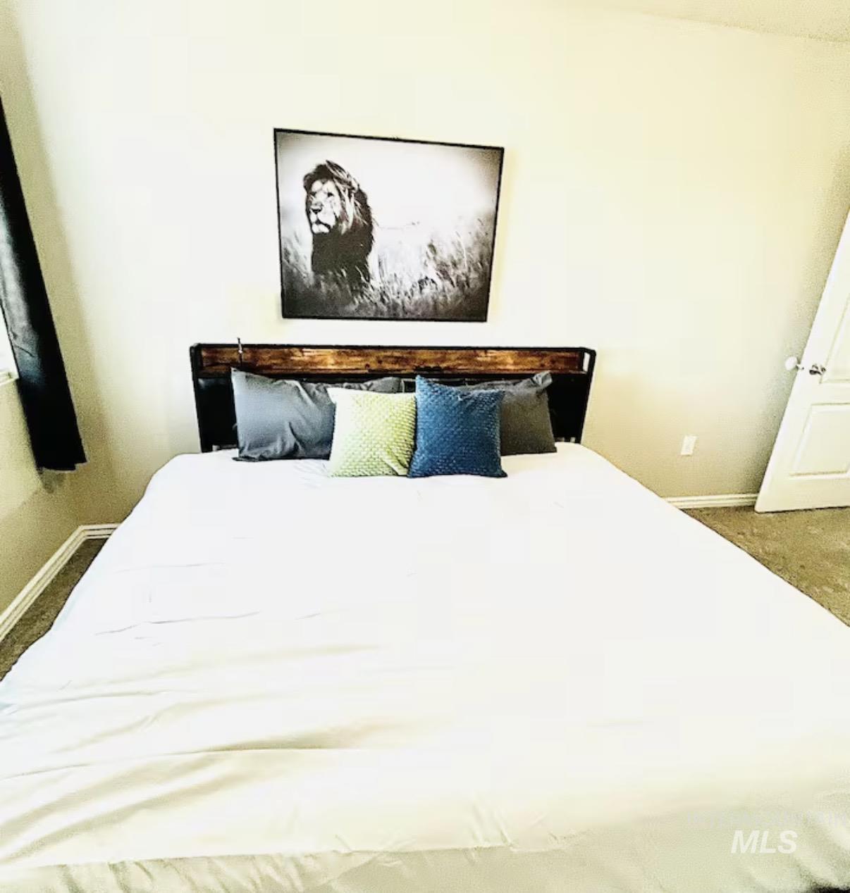 Bedroom featuring dark carpet and baseboards