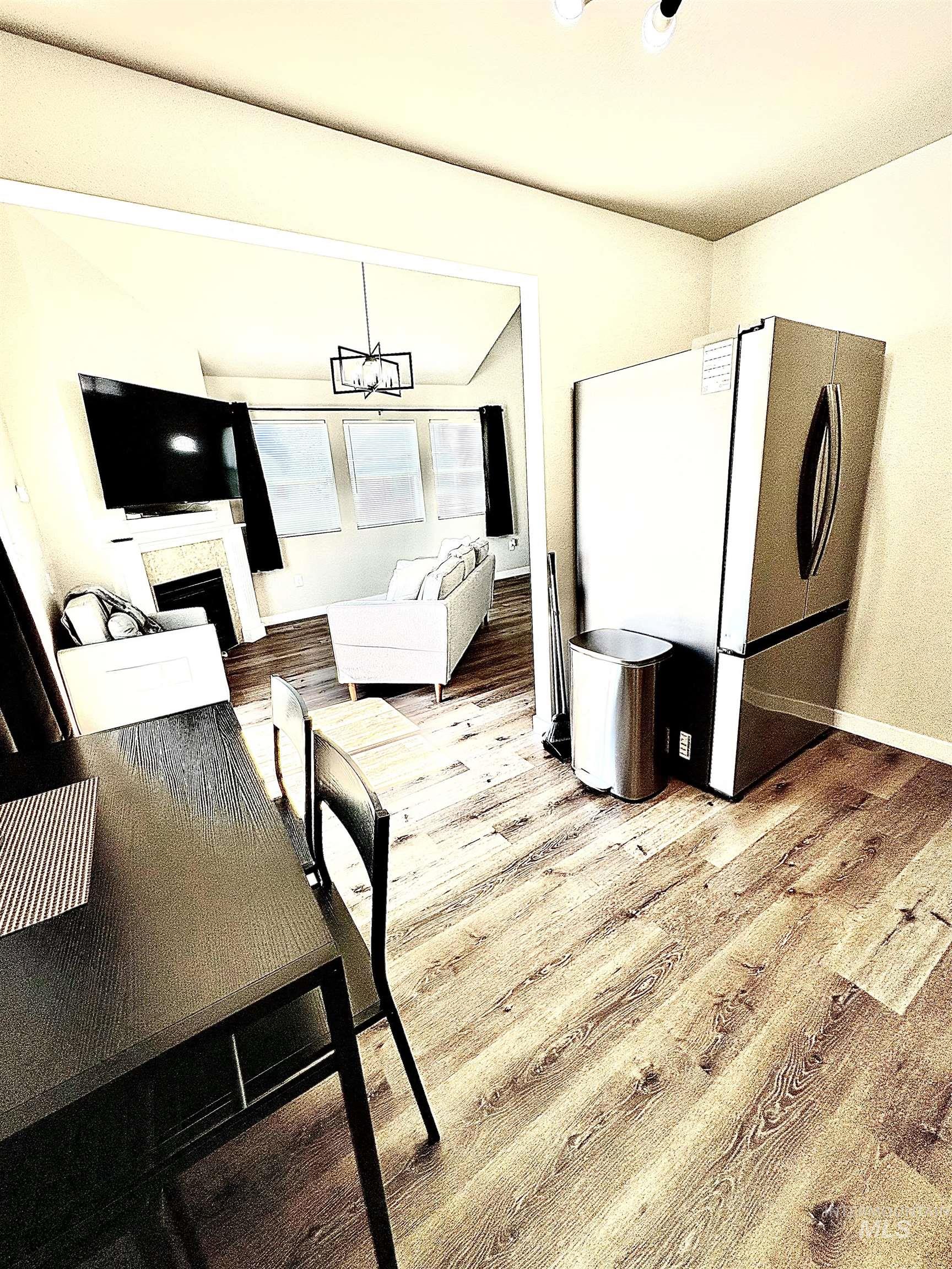 Dining room featuring a fireplace, light wood-style floors, and a chandelier