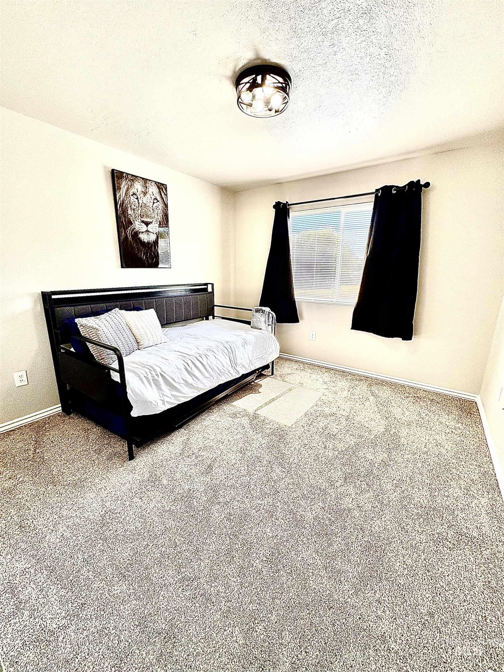Carpeted bedroom with baseboards and a textured ceiling