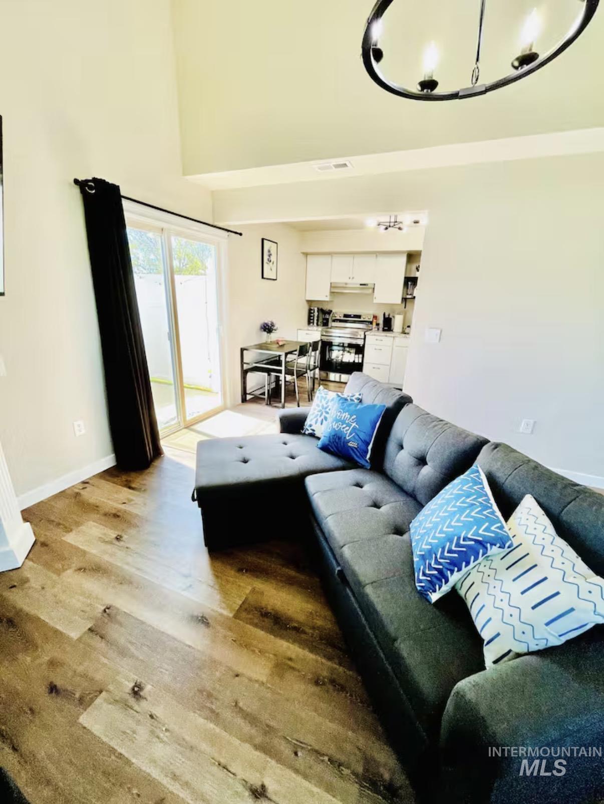 Living area with light wood finished floors and a towering ceiling