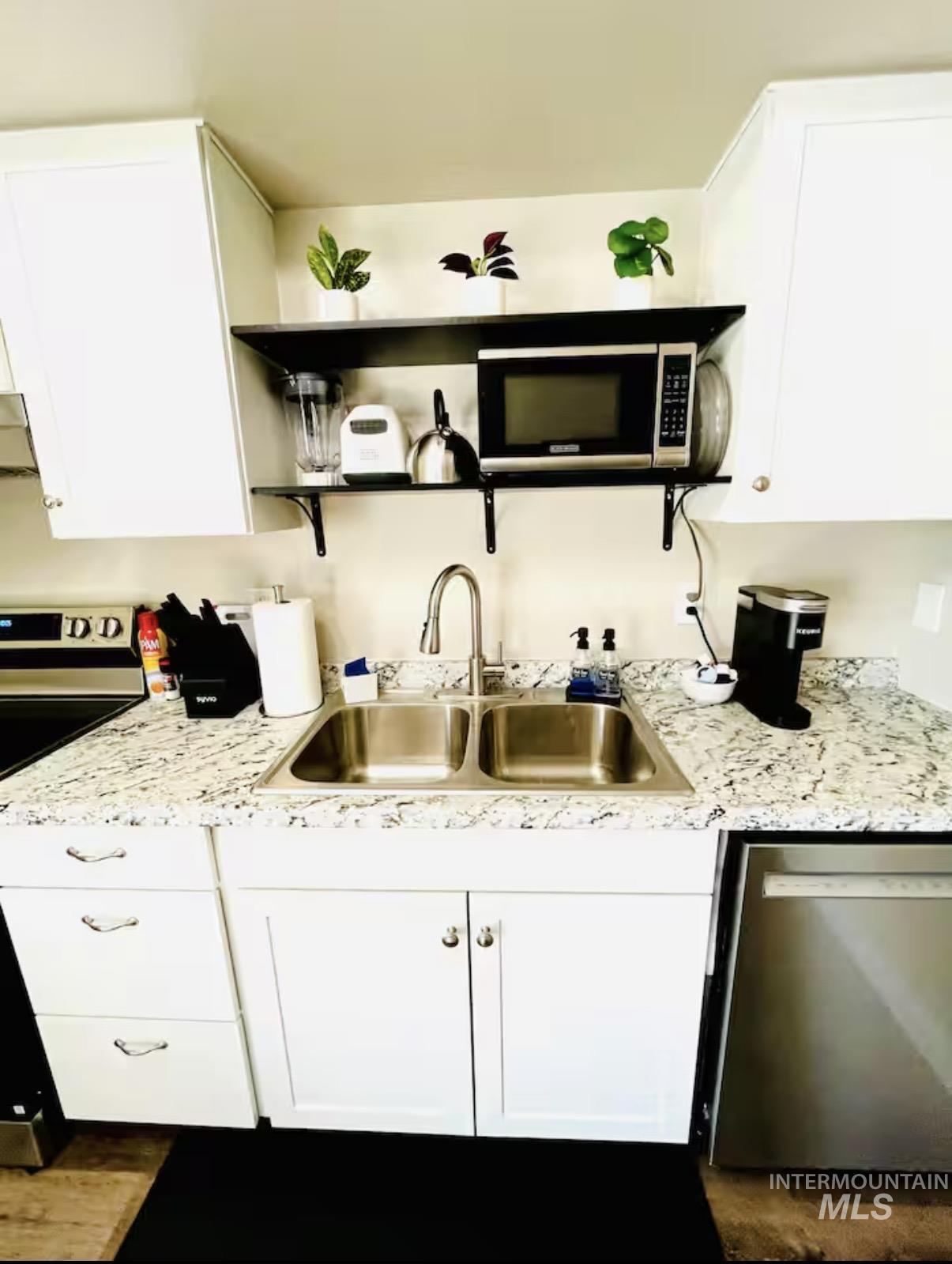 Kitchen with open shelves, white cabinetry, stainless steel appliances, and range hood