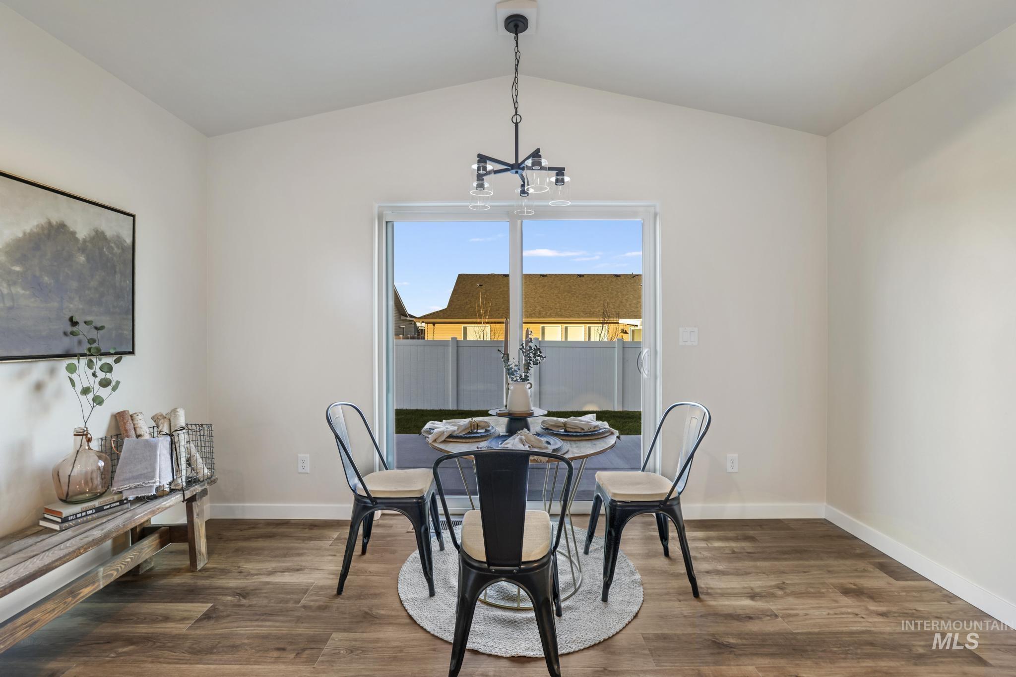 Dining space featuring wood finished floors and lofted ceiling