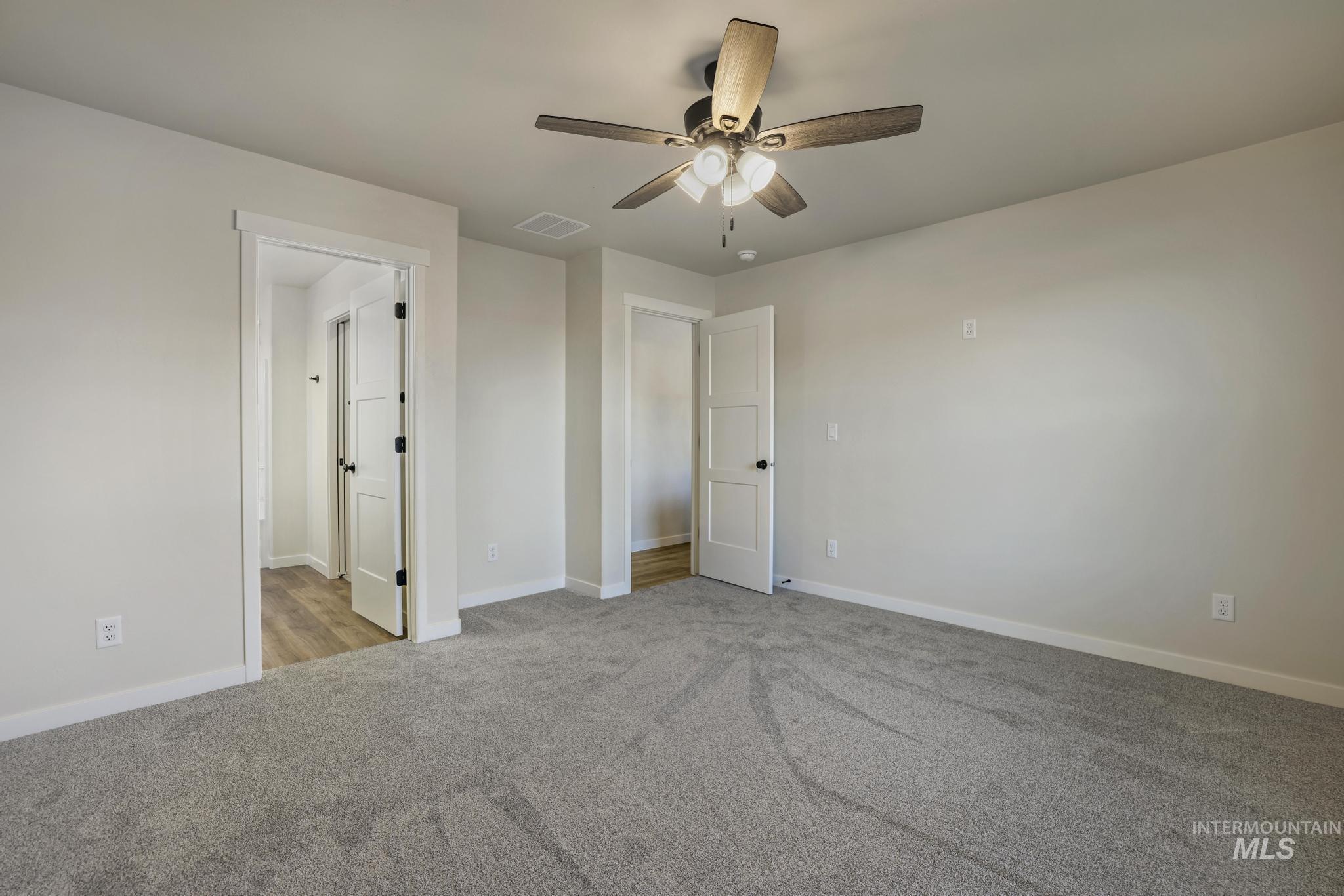 Unfurnished bedroom featuring ceiling fan and light colored carpet