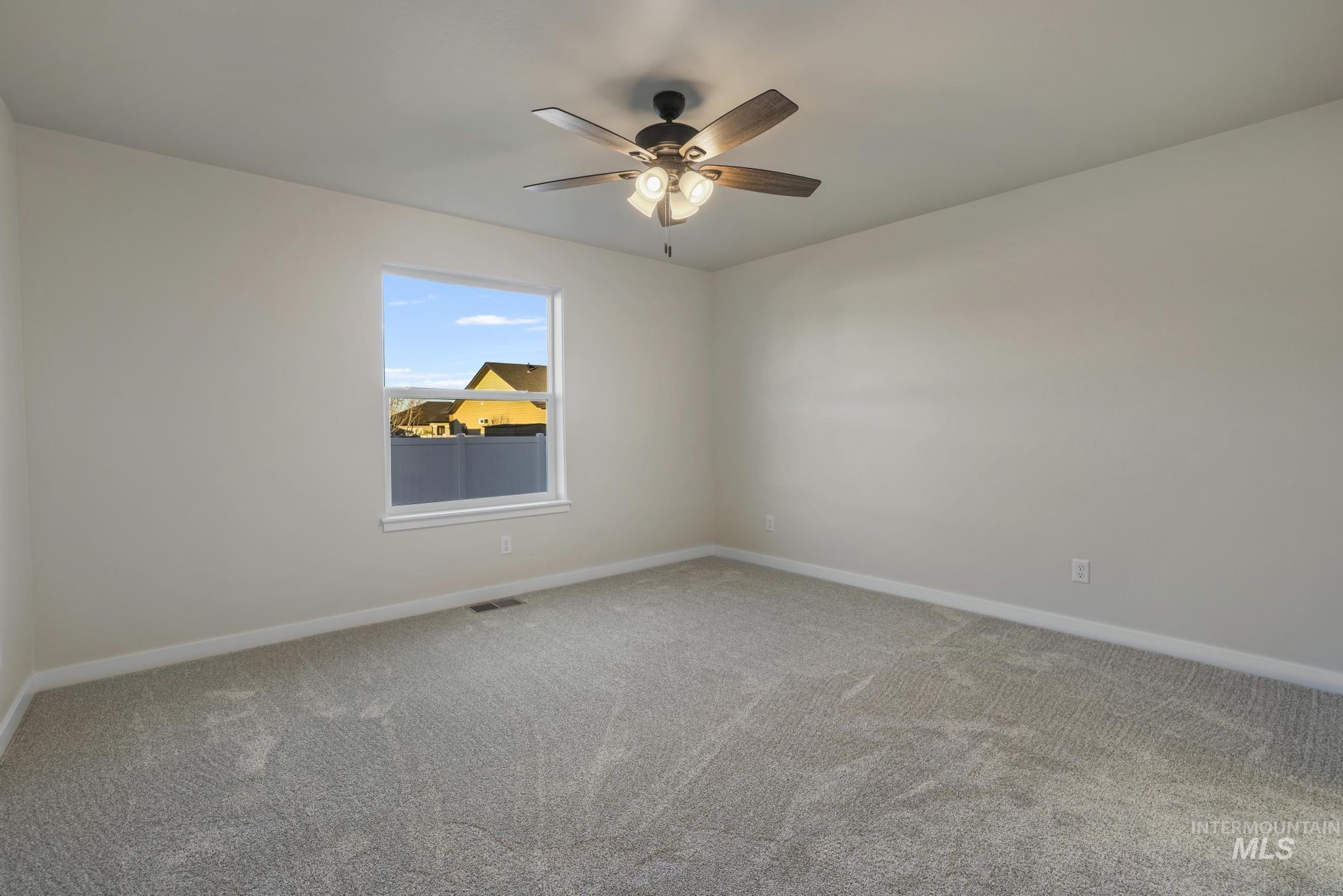Unfurnished room featuring carpet floors and ceiling fan