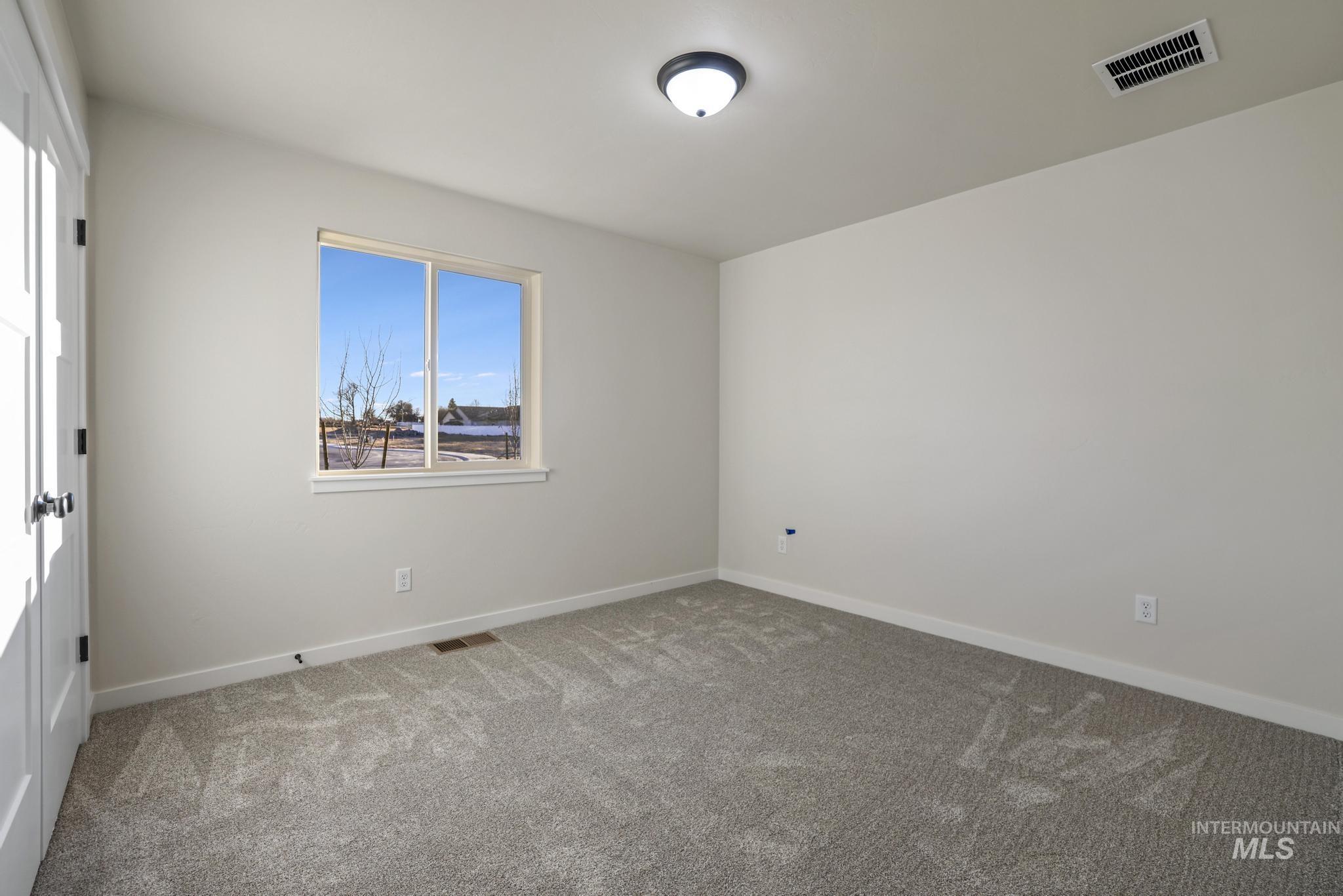 Spare room featuring baseboards and carpet floors