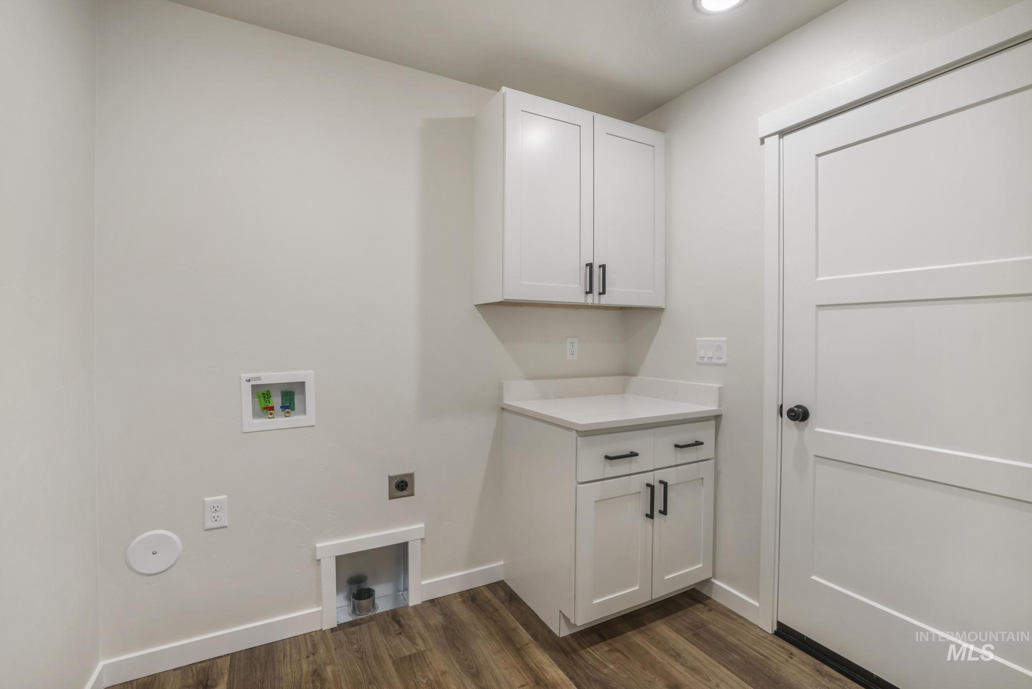 Laundry area with washer hookup, dark wood finished floors, electric dryer hookup, and cabinet space