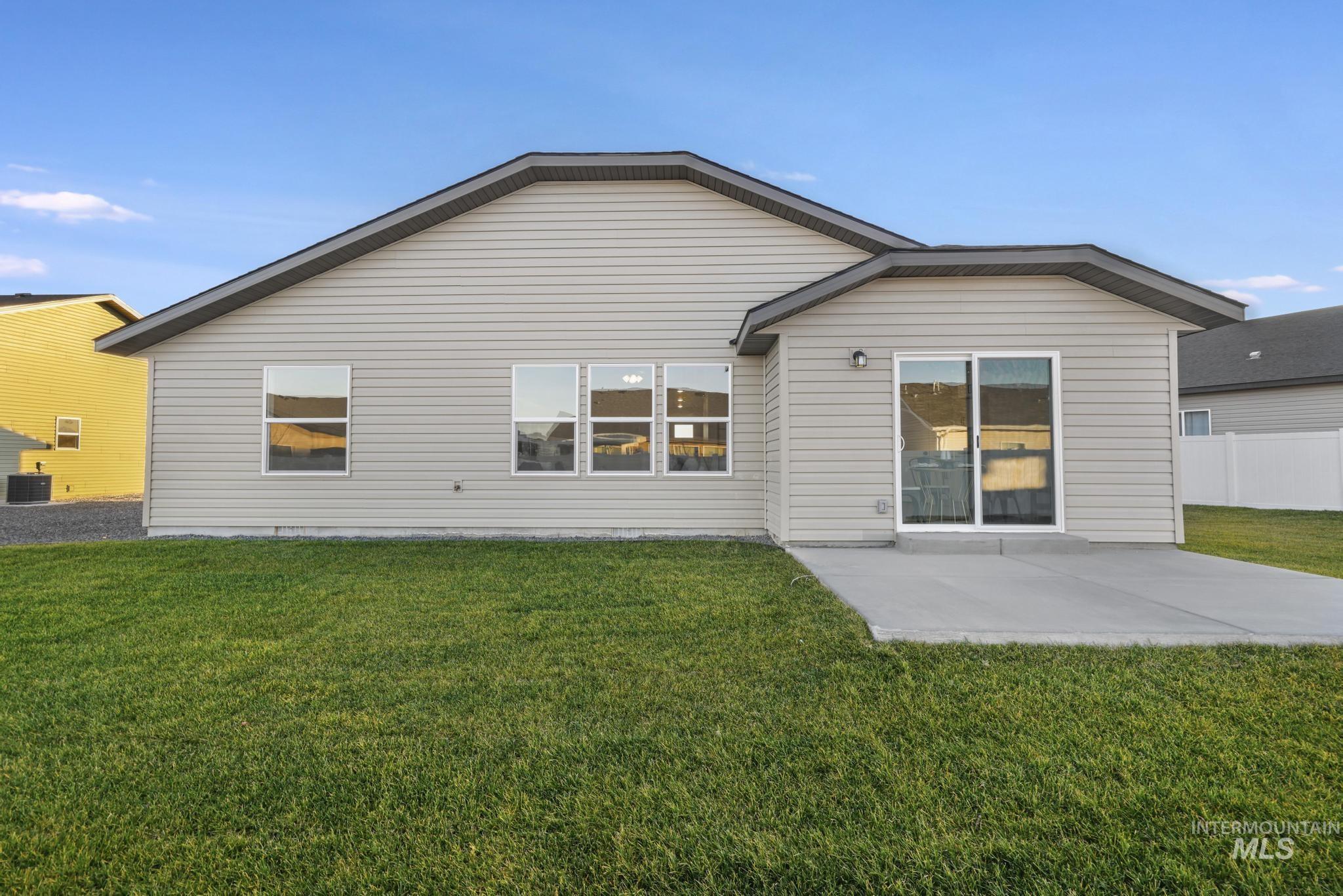 Back of property featuring a yard and a patio area