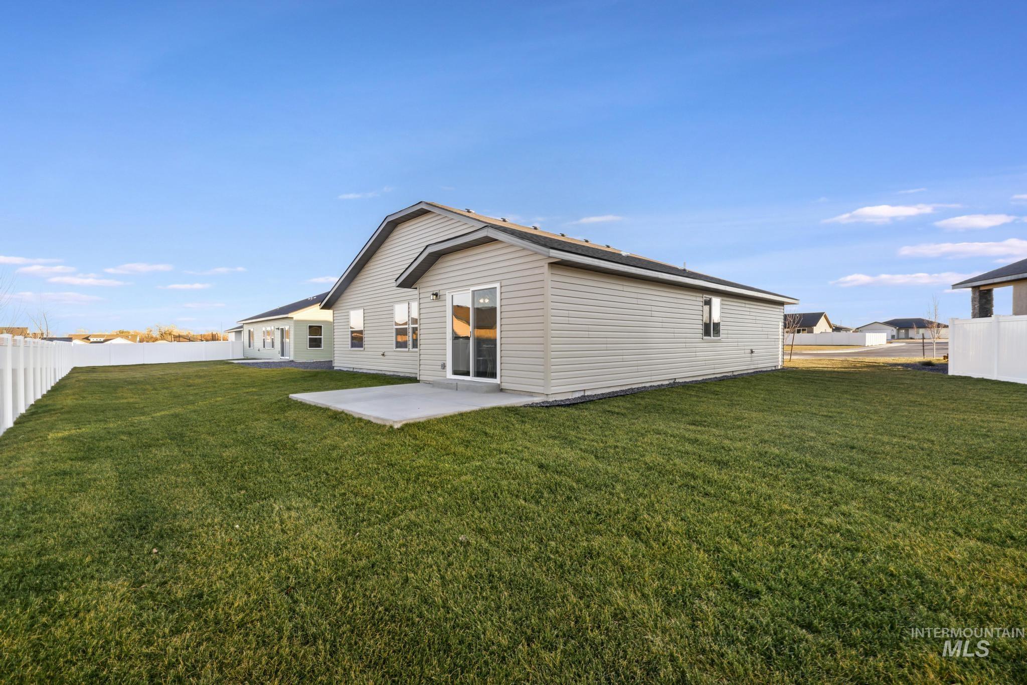 Rear view of house featuring a fenced backyard and a patio area