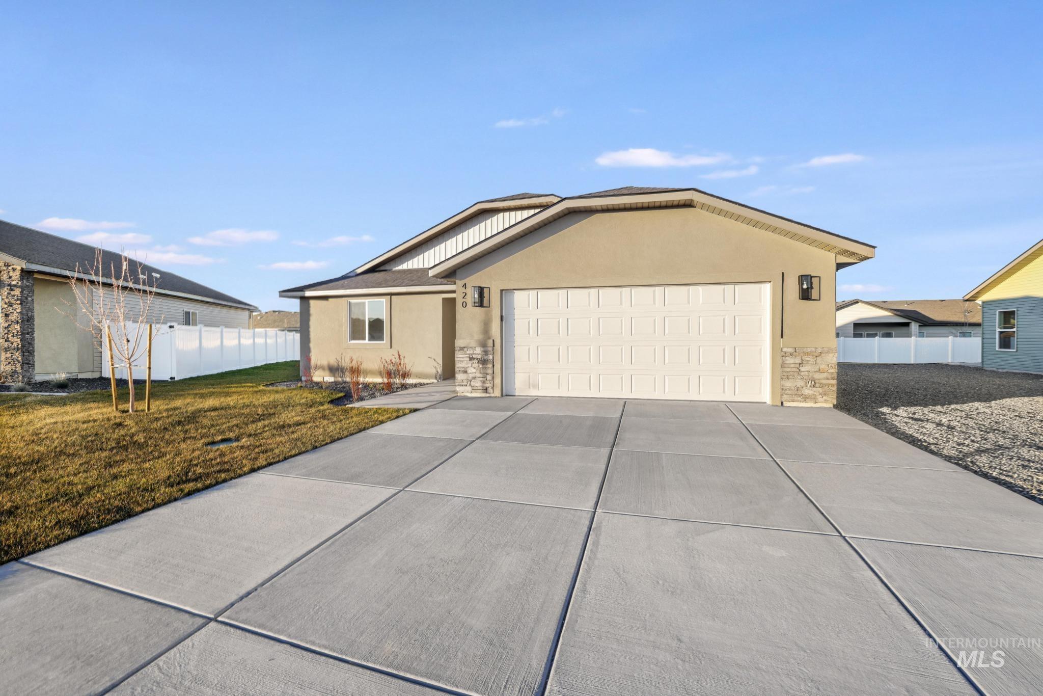 Ranch-style home with stone siding, stucco siding, concrete driveway, and an attached garage
