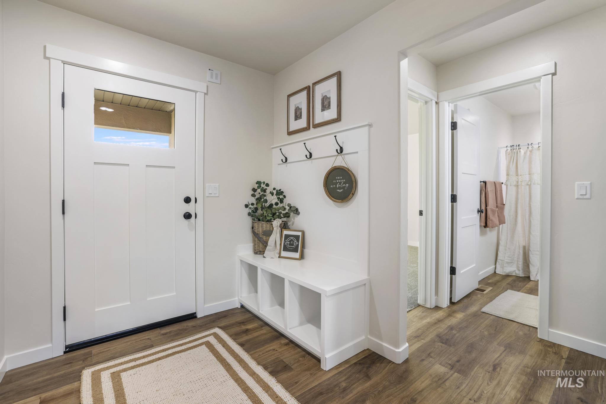 Mudroom with dark wood-style flooring and baseboards