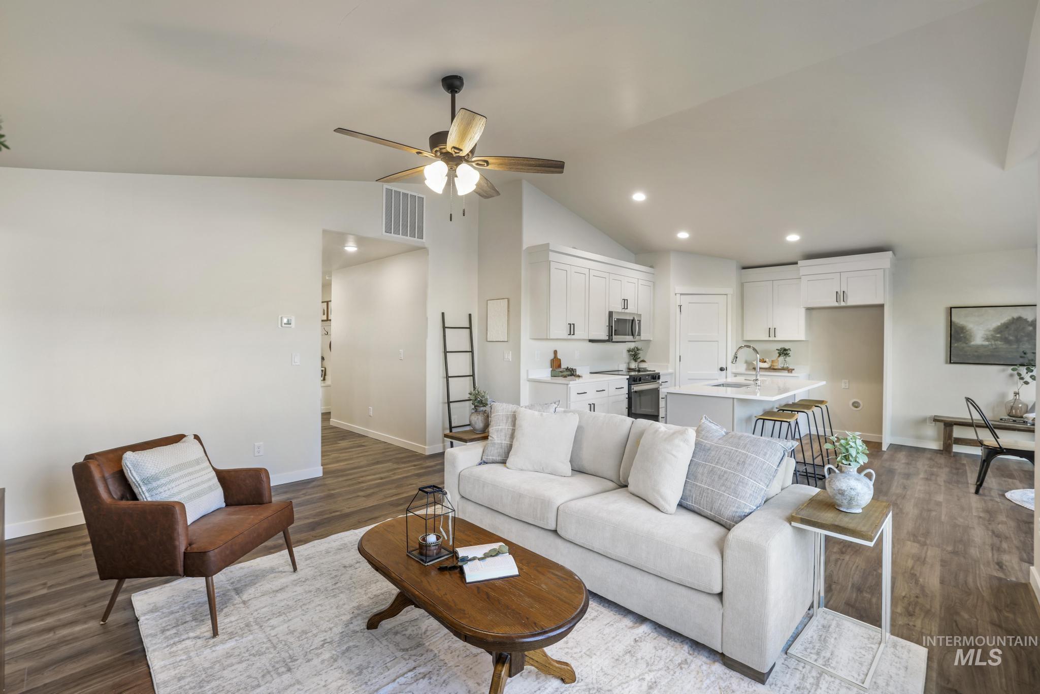 Living area with a ceiling fan, dark wood-style floors, vaulted ceiling, and recessed lighting