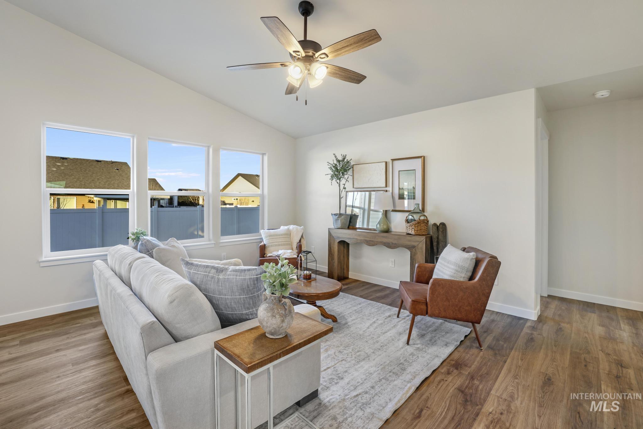 Living room featuring lofted ceiling, wood finished floors, and ceiling fan