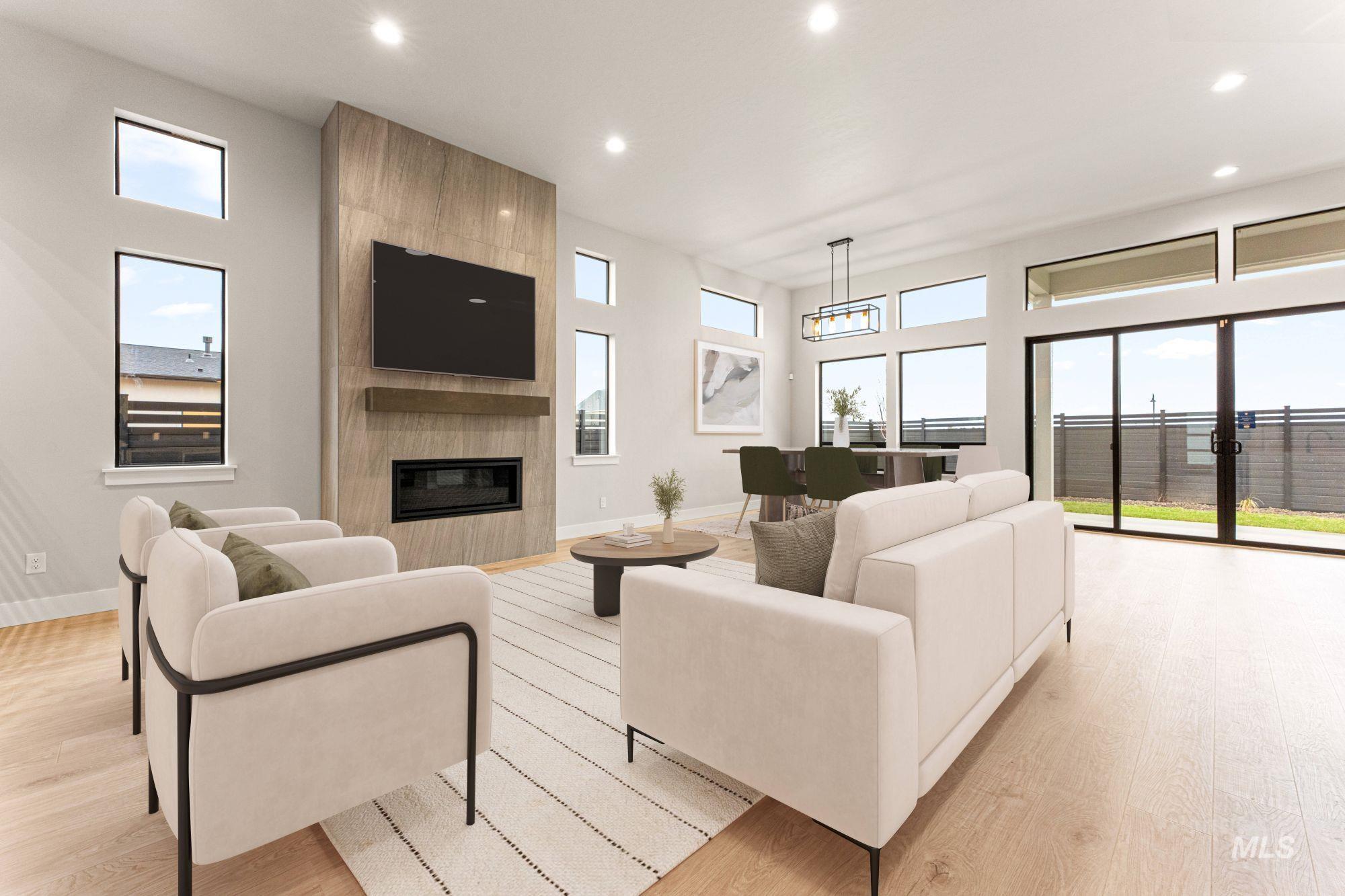 Living room with plenty of natural light, light wood-style flooring, recessed lighting, a fireplace, and a high ceiling