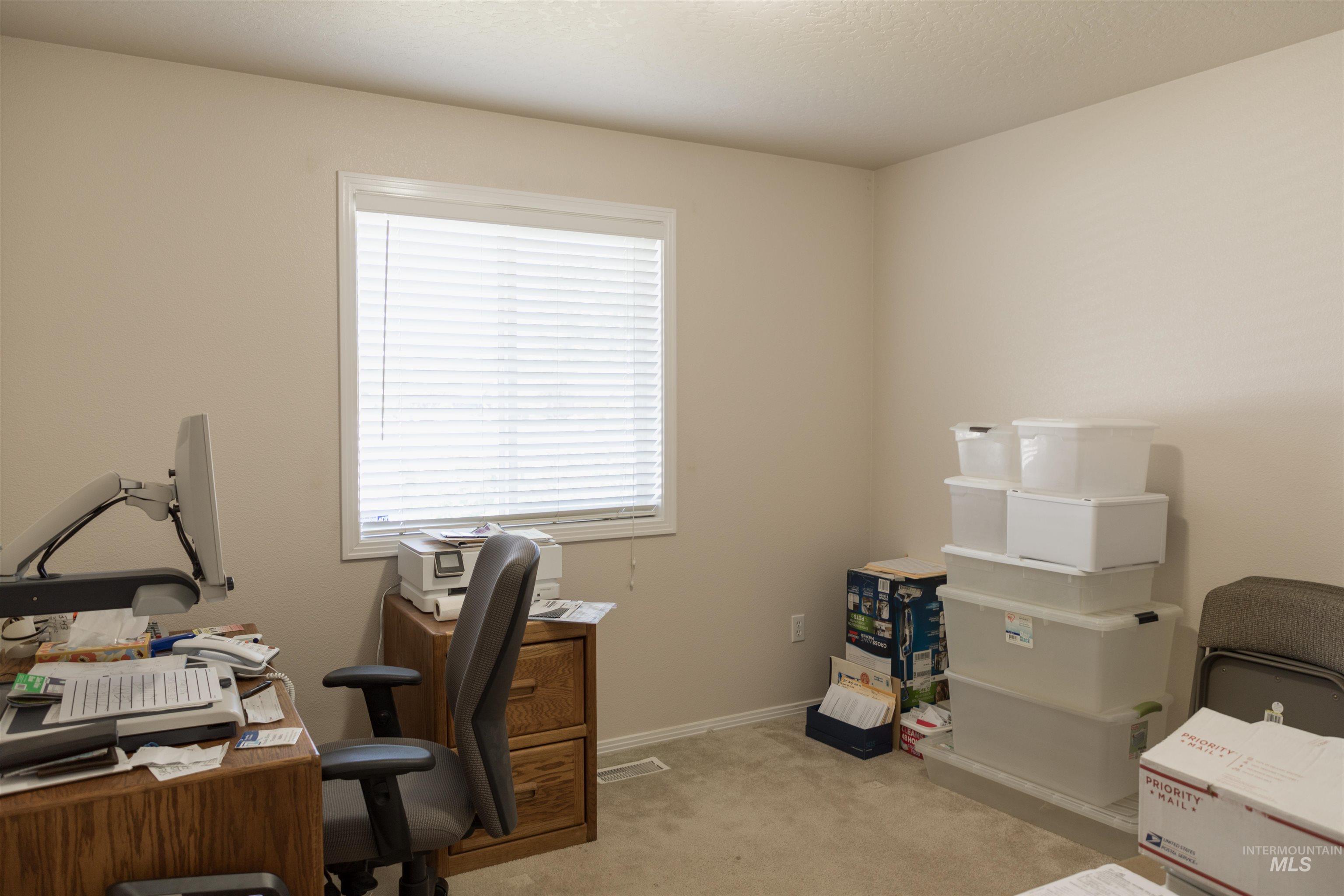 Office space featuring light colored carpet and baseboards