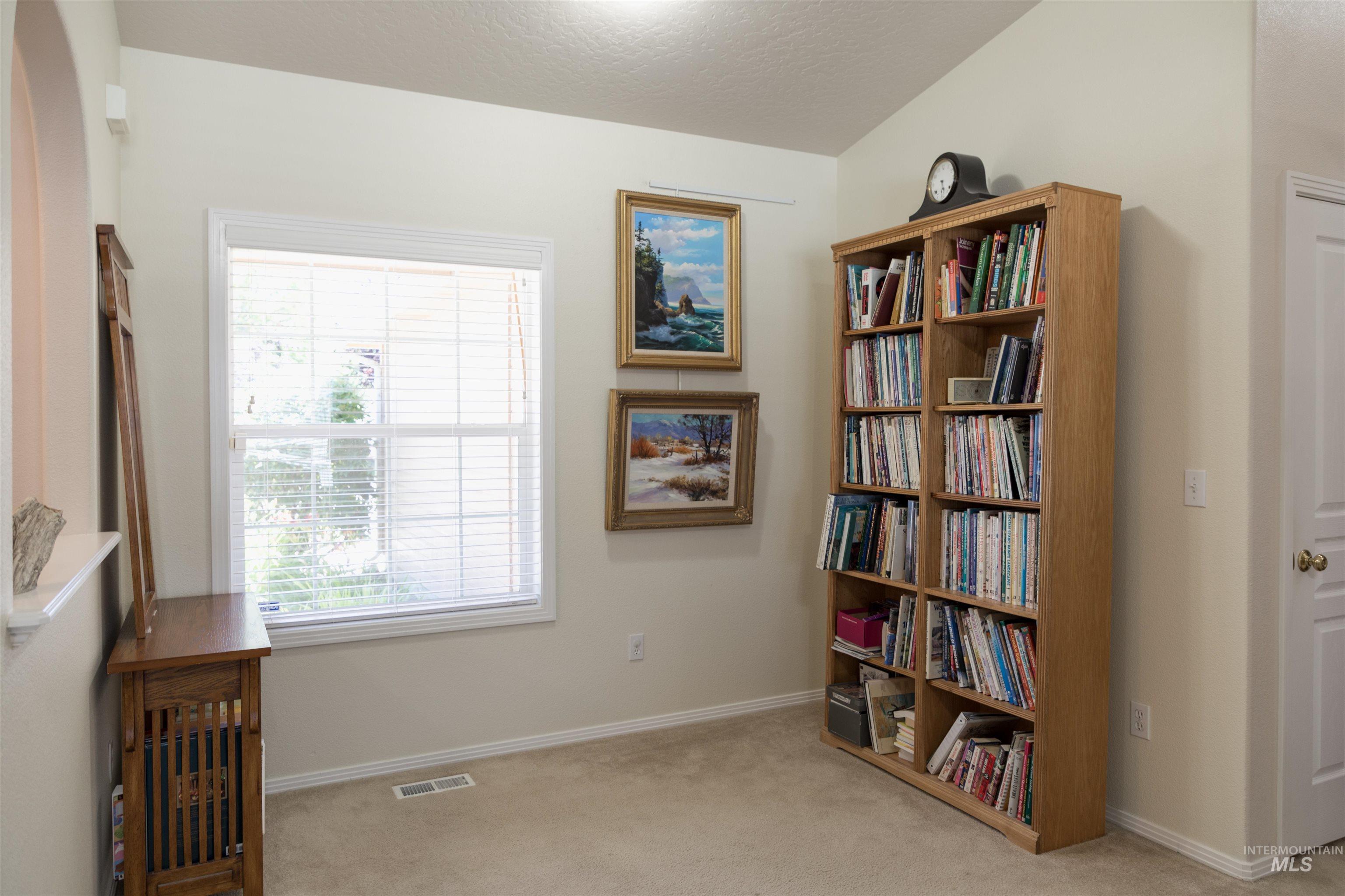 Living area with light carpet and a textured ceiling