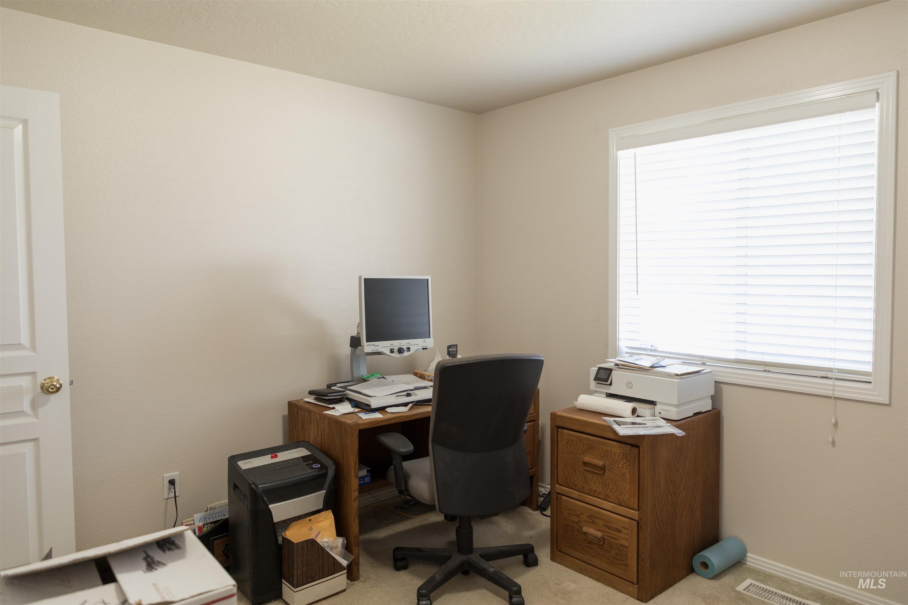 Home office with light carpet and baseboards
