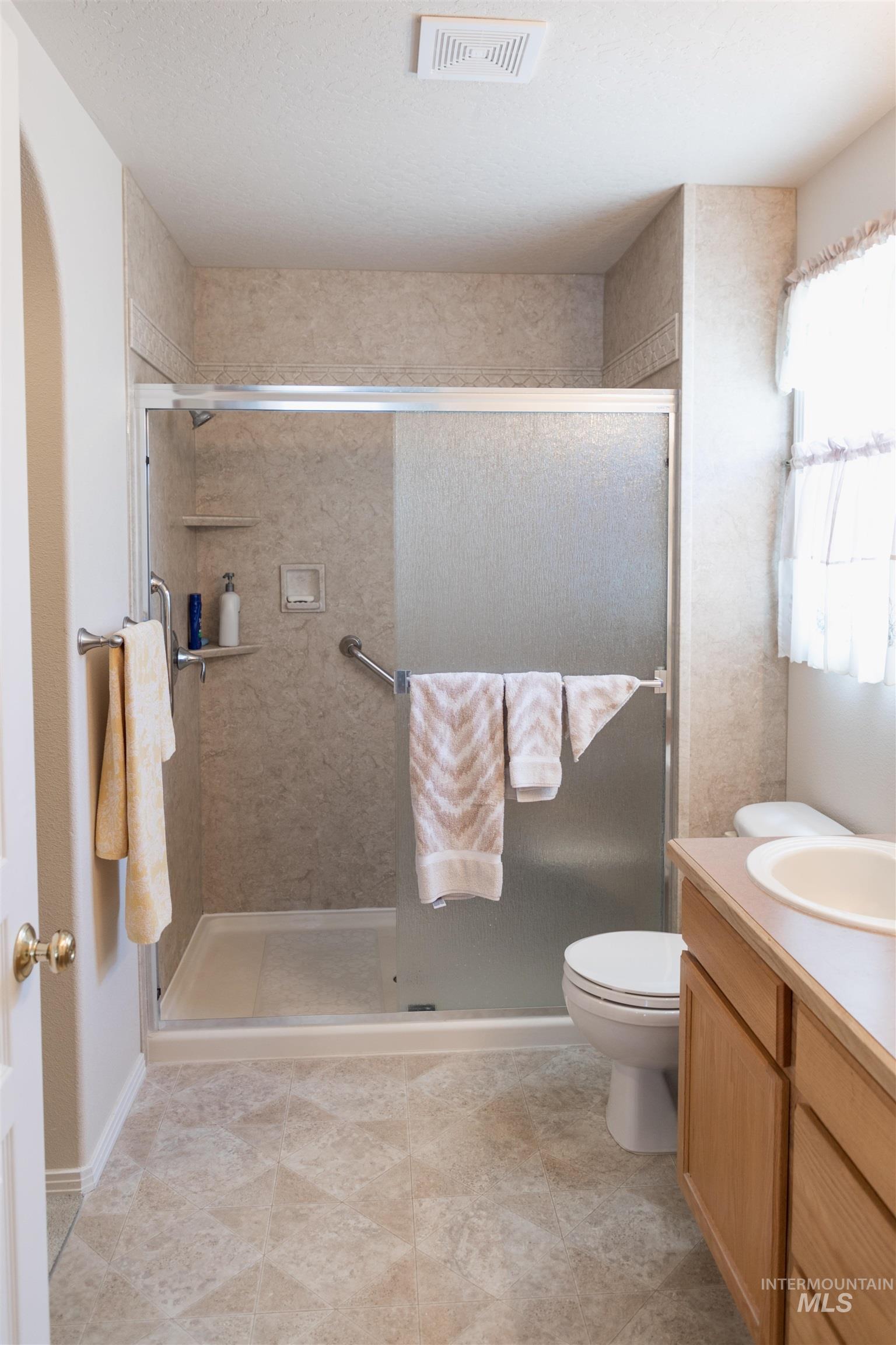 Bathroom featuring vanity and a shower stall