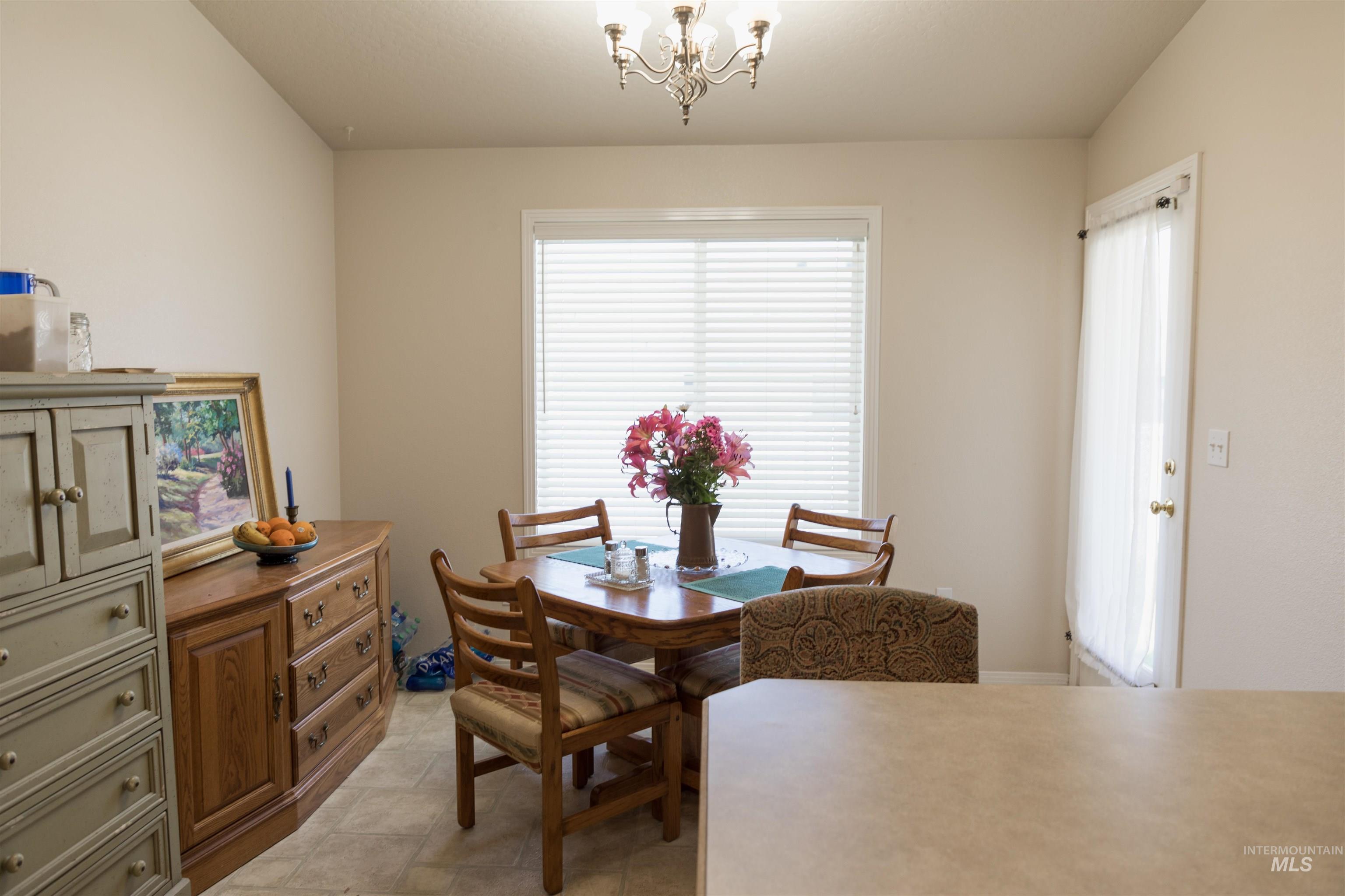 Dining space with a chandelier and light tile patterned flooring
