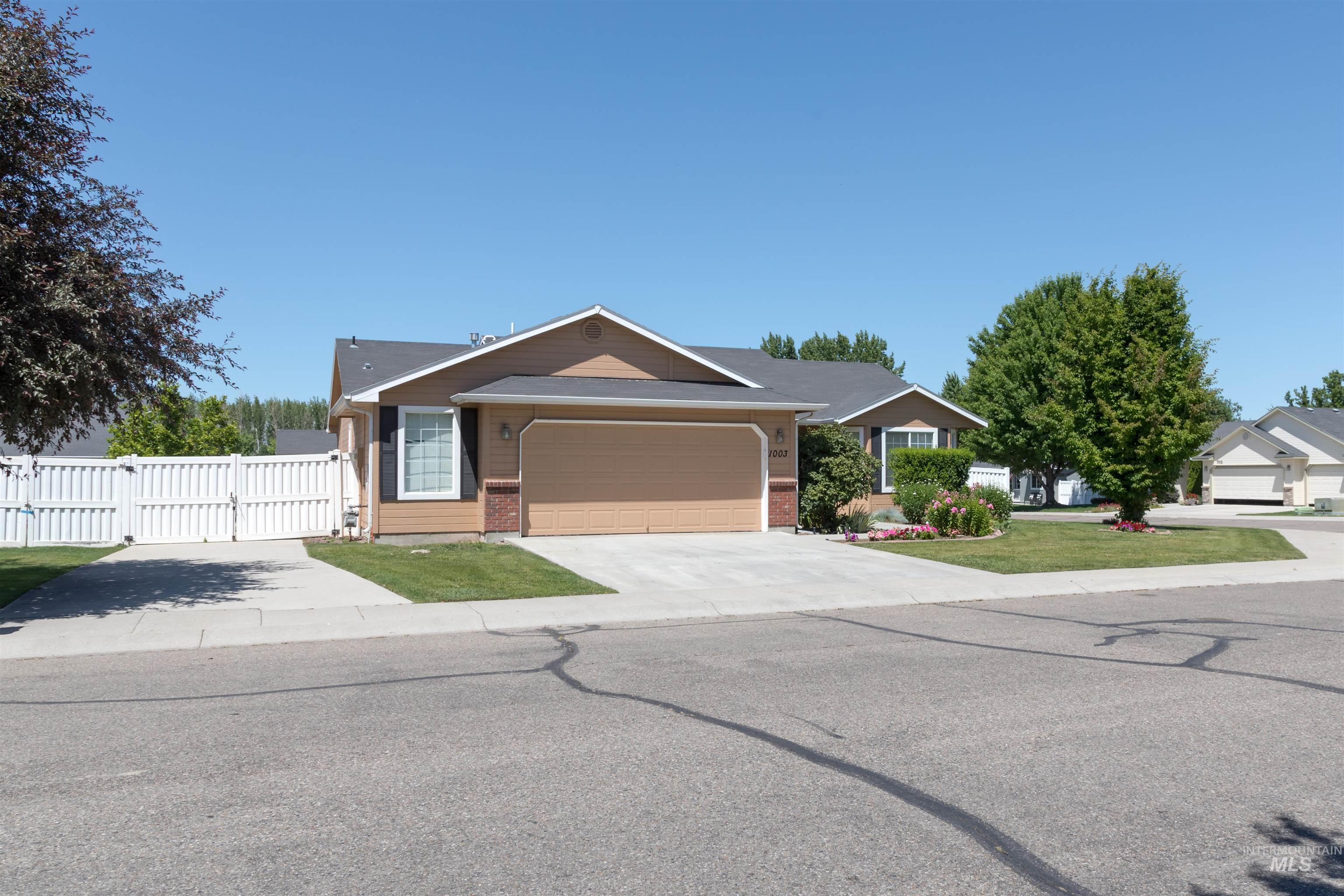 Single story home featuring a gate, brick siding, concrete driveway, and a garage