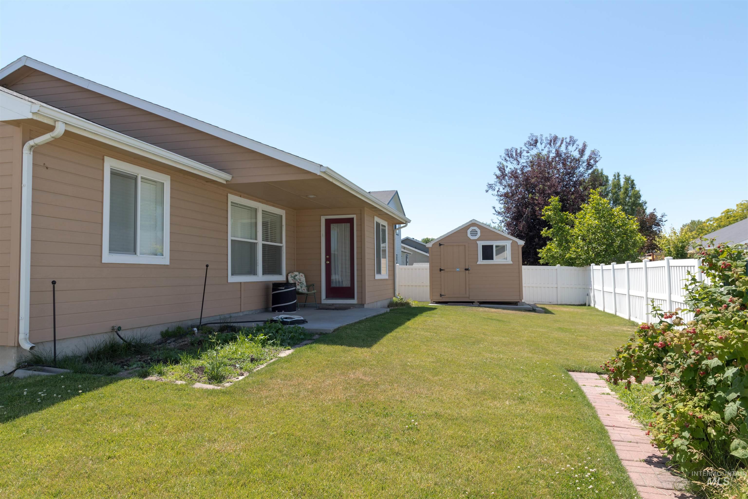 Fenced backyard featuring a shed and a patio