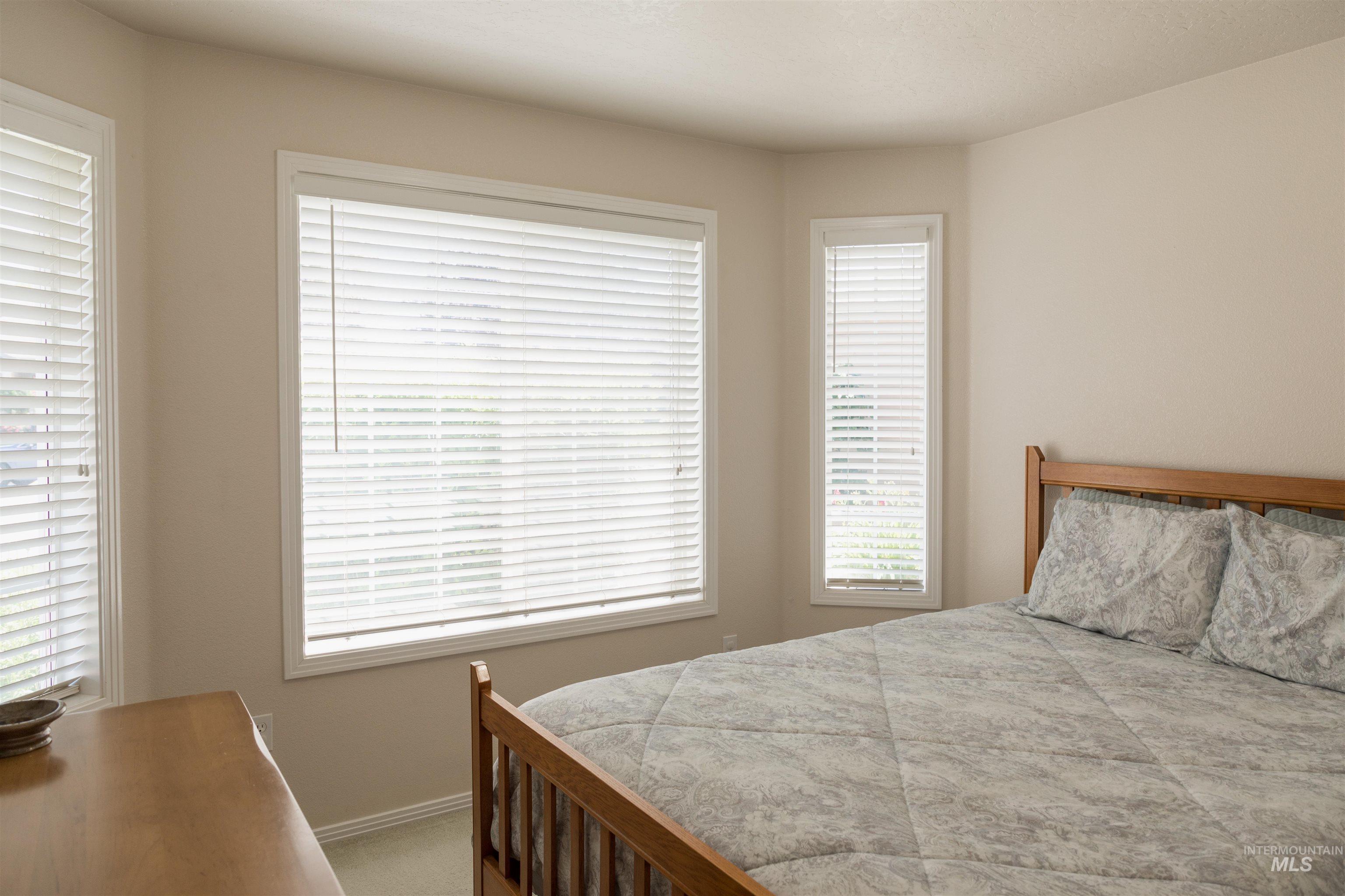 Bedroom with light colored carpet and baseboards