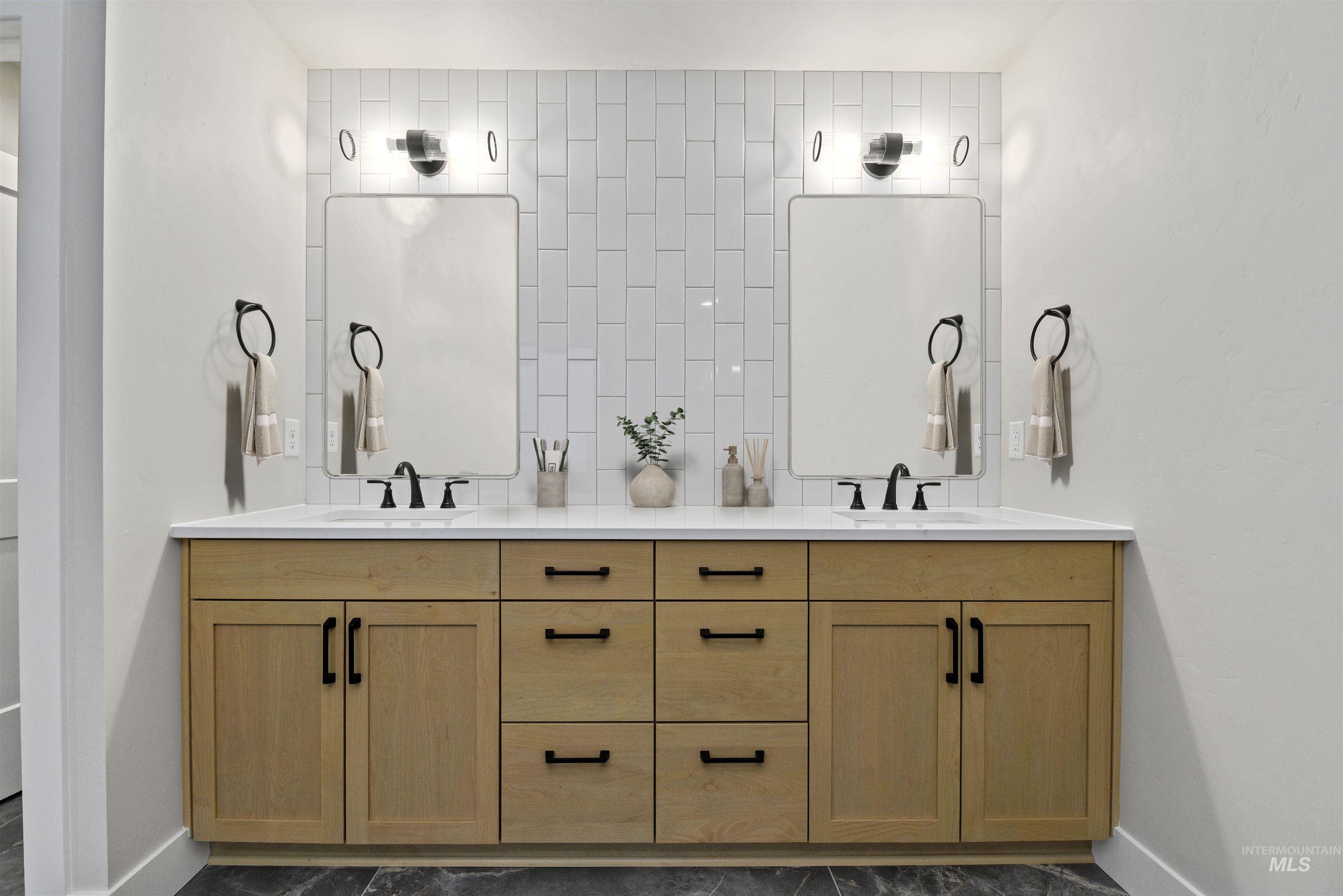 Full bath featuring double vanity and decorative backsplash