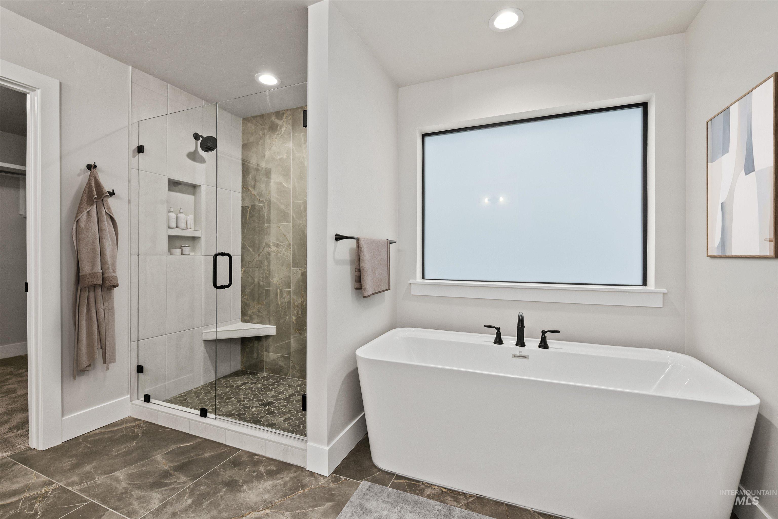 Full bath with a soaking tub, a stall shower, dark marble finish floors, a walk in closet, and recessed lighting