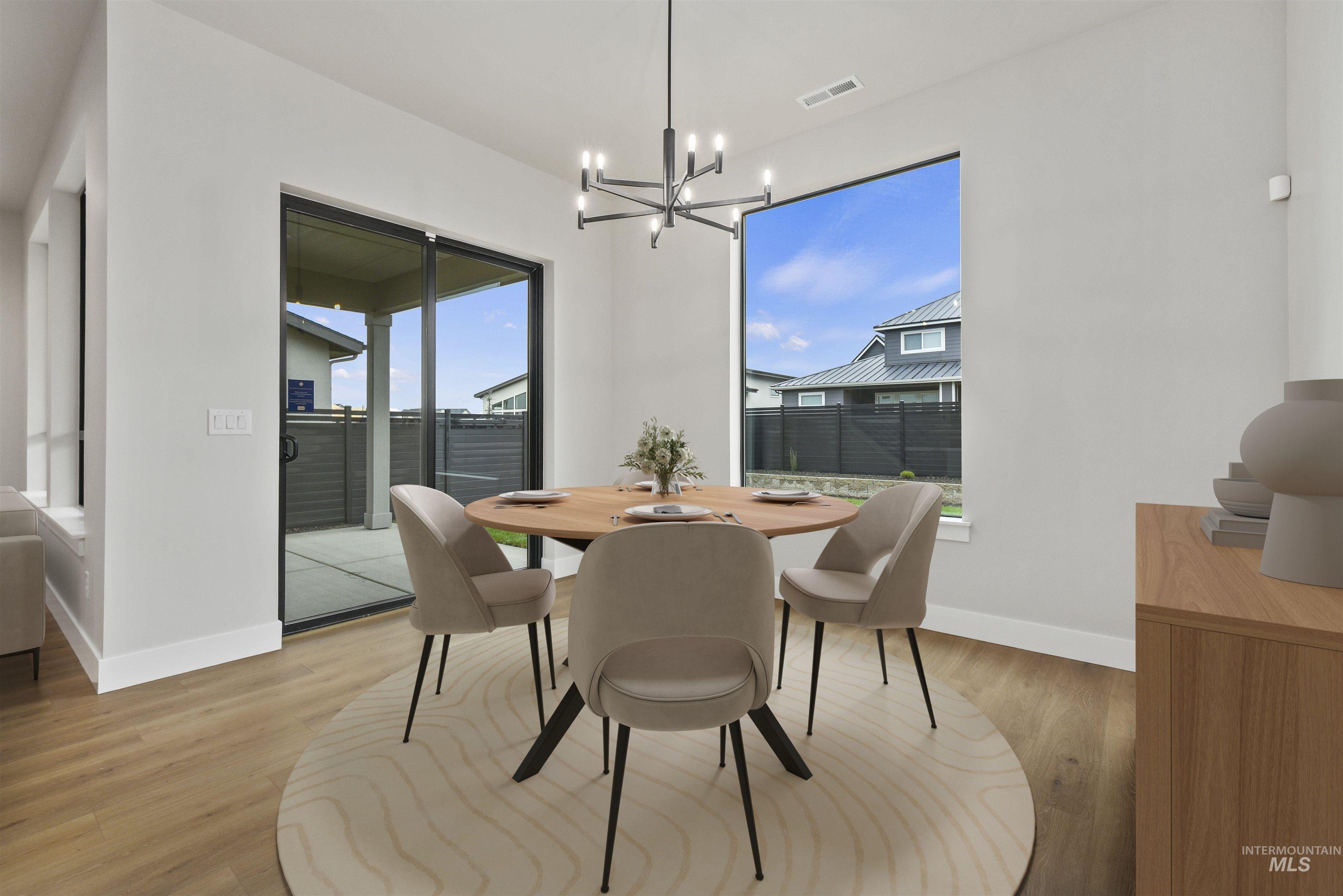 Dining area with light wood finished floors and a chandelier