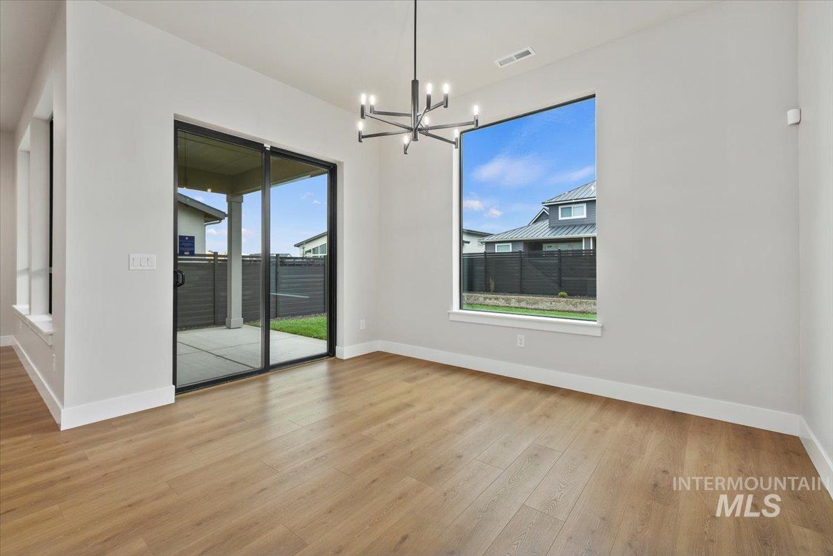 Unfurnished dining area with light wood-style flooring and a chandelier