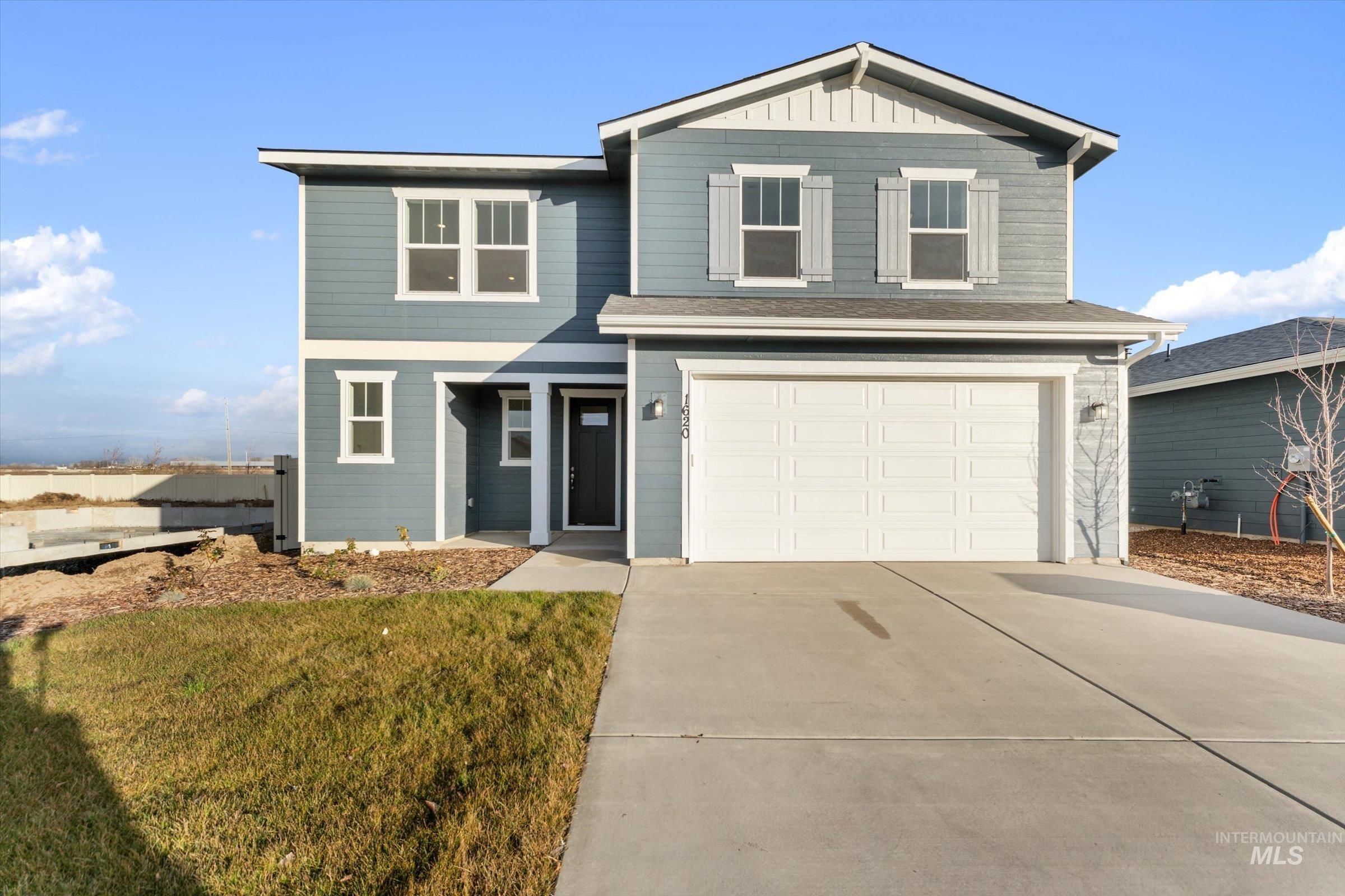 View of front facade featuring driveway, a garage, and board and batten siding