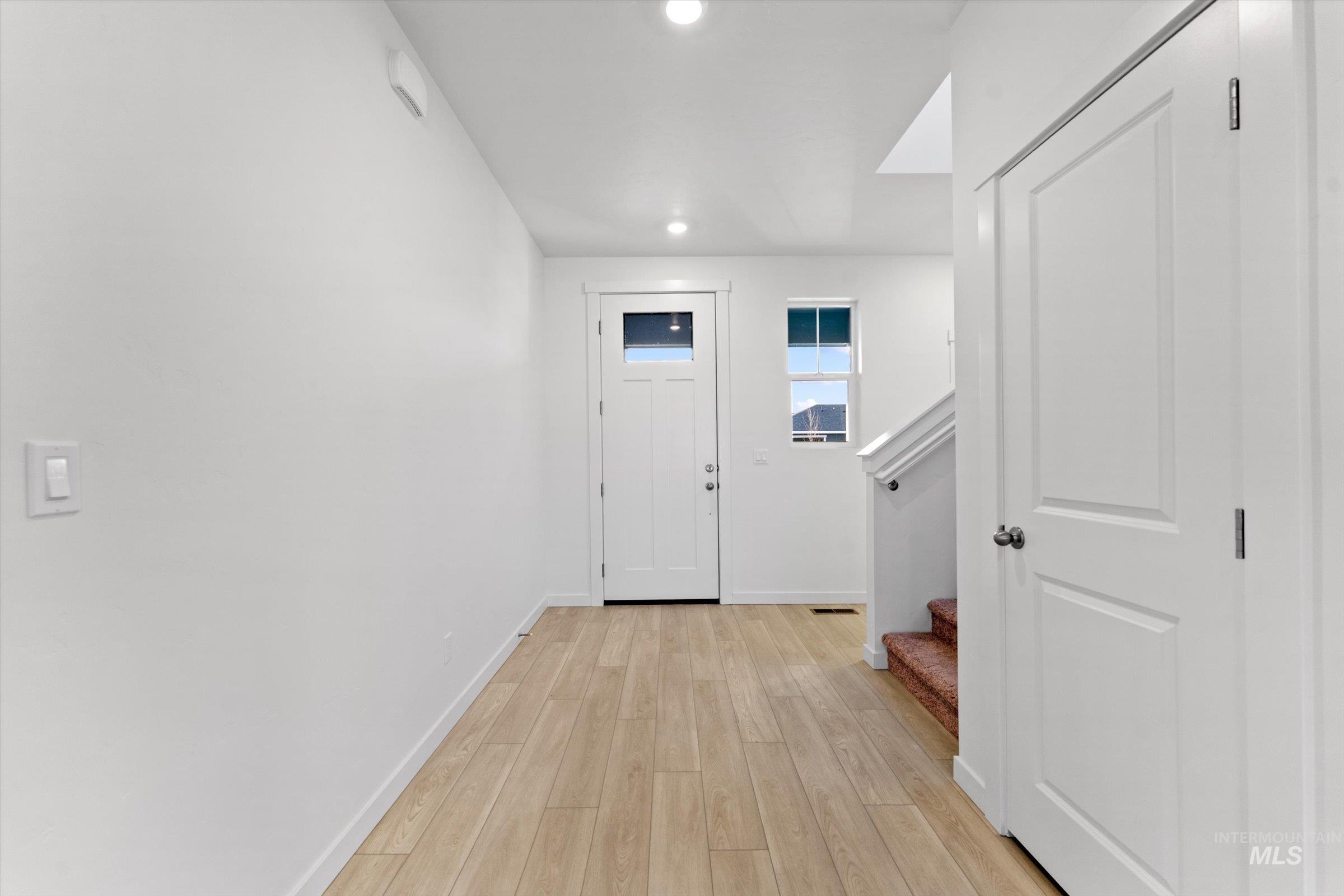 Doorway to outside with hardwood / wood-style flooring, recessed lighting, and stairs