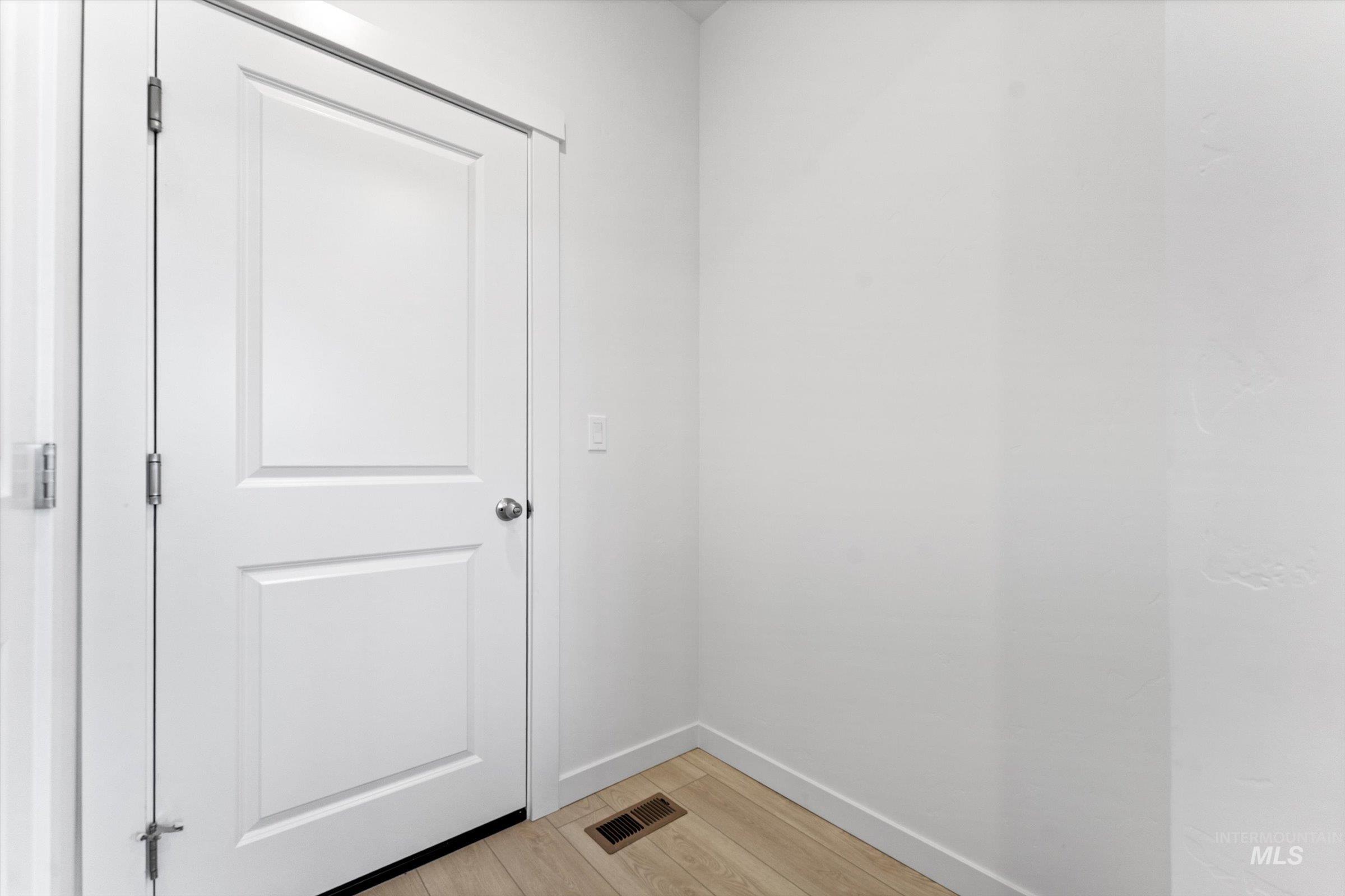 Washroom with light wood-type flooring and baseboards