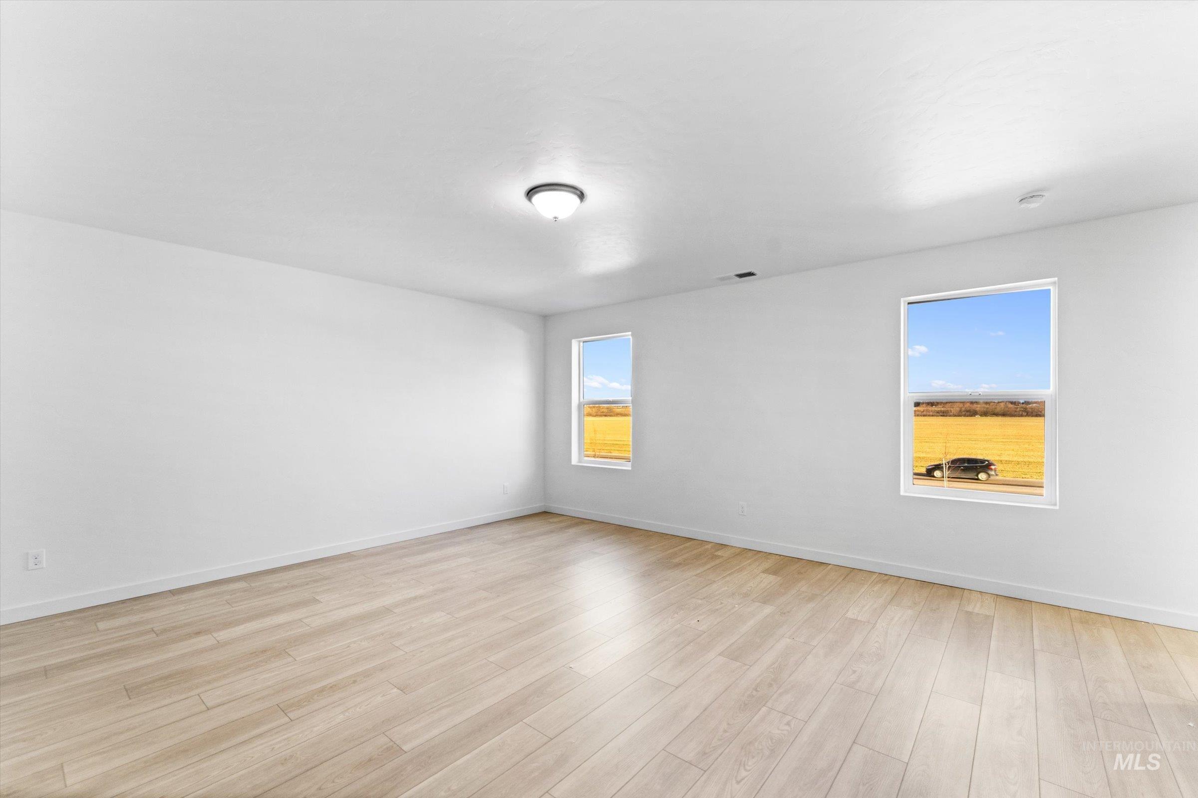 Spare room with light wood-style flooring and baseboards