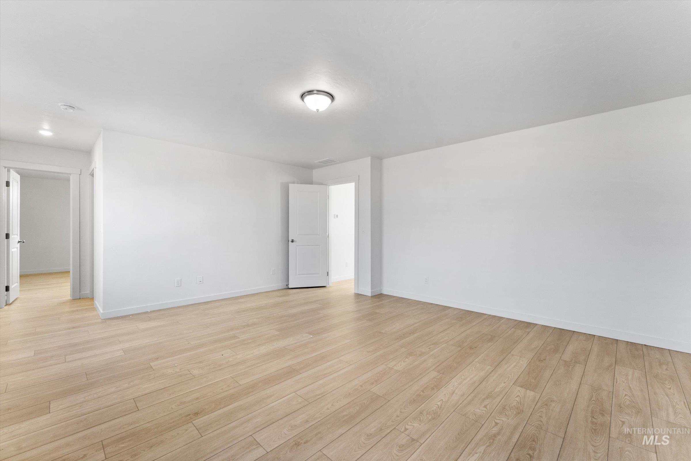Unfurnished room with light wood-style flooring and baseboards
