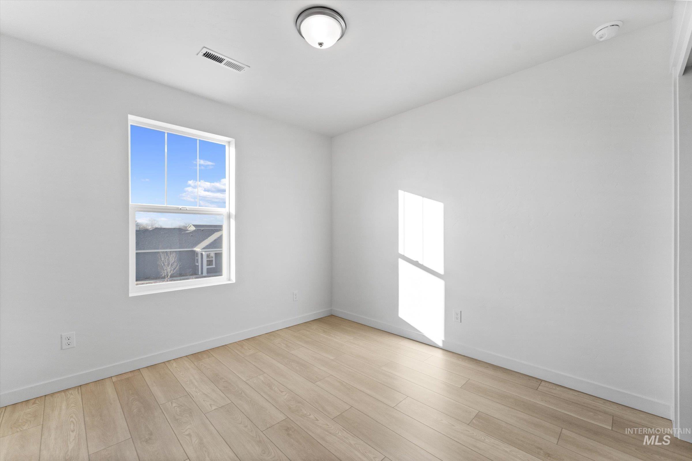 Empty room with light wood-style flooring and baseboards
