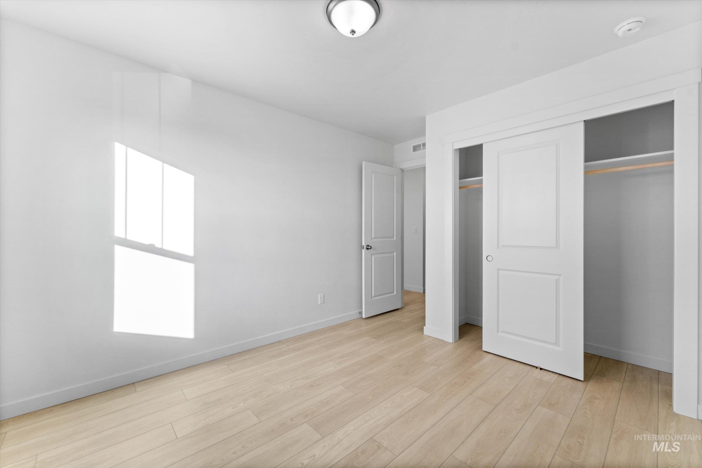 Unfurnished bedroom with a closet and light wood-type flooring